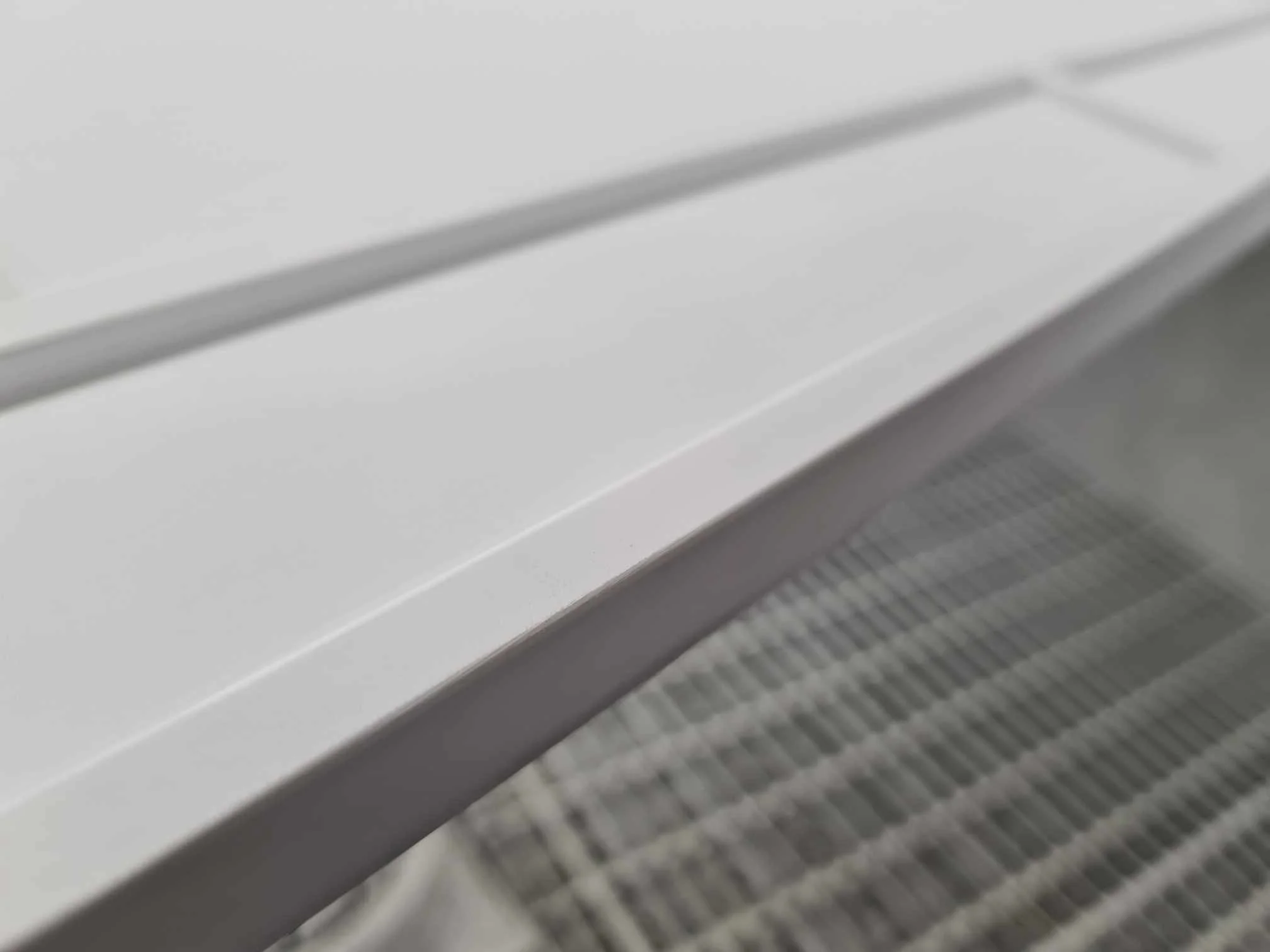 Close-up of a white air conditioning unit with a vent and control panel.