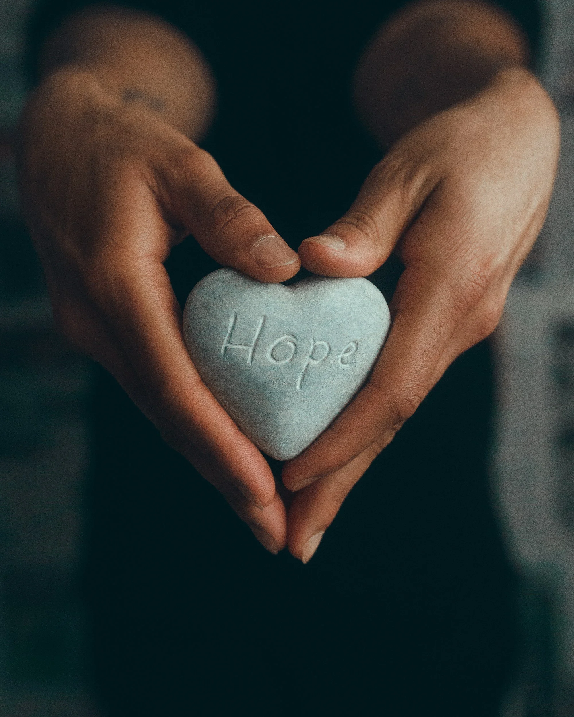 Hands hold a green heart saying "hope" on them. Hopeful EMDR therapy.