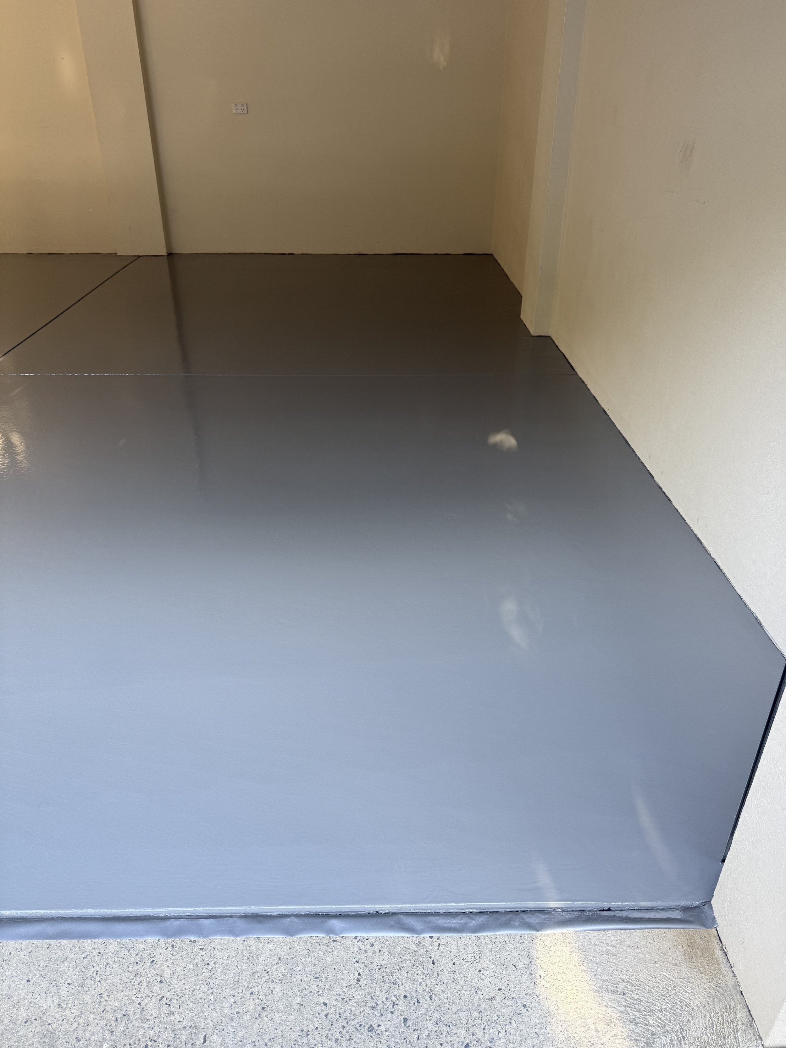 Epoxy ash grey with beige walls and a closed white door.