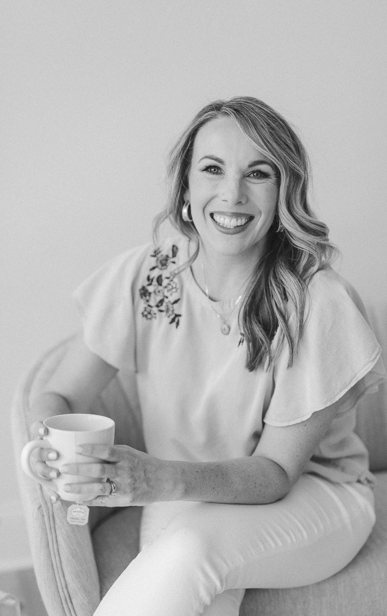 a natural headshot of a woman holding a cup of tea
