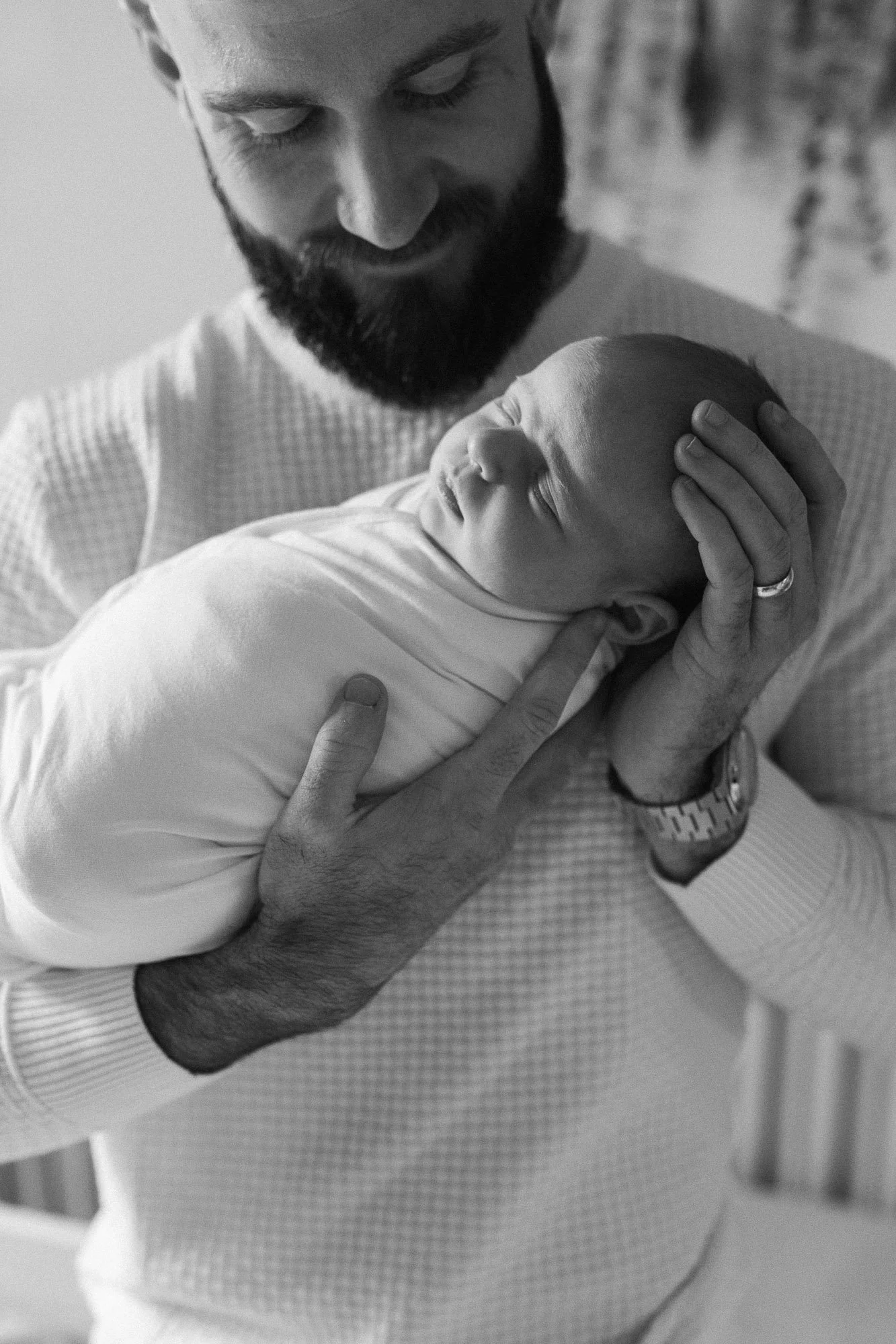 black and white image of a dad gazing down at his baby girl during a Chicago newborn photo session