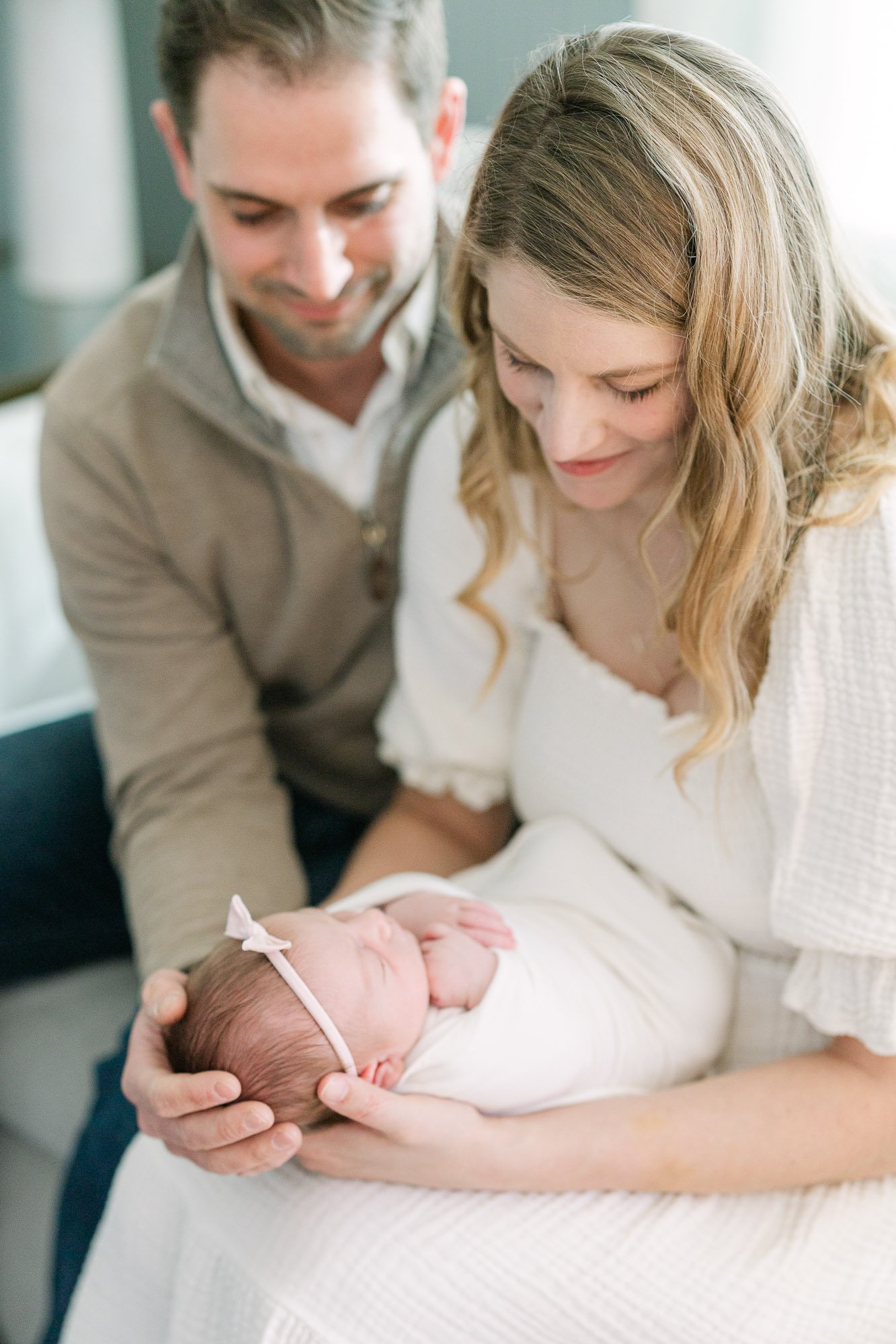 a couple gazing at their newborn baby girl with a light and airy film-like aesthetic by Christi Lynn Photography