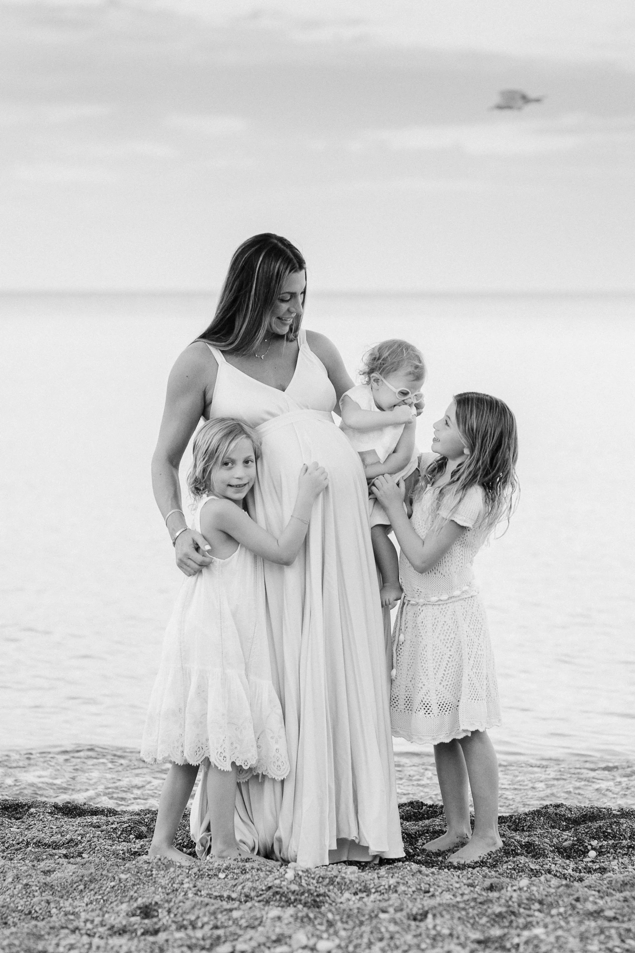 A pregnant mom with her three little girls during a maternity session on Glencoe Beach