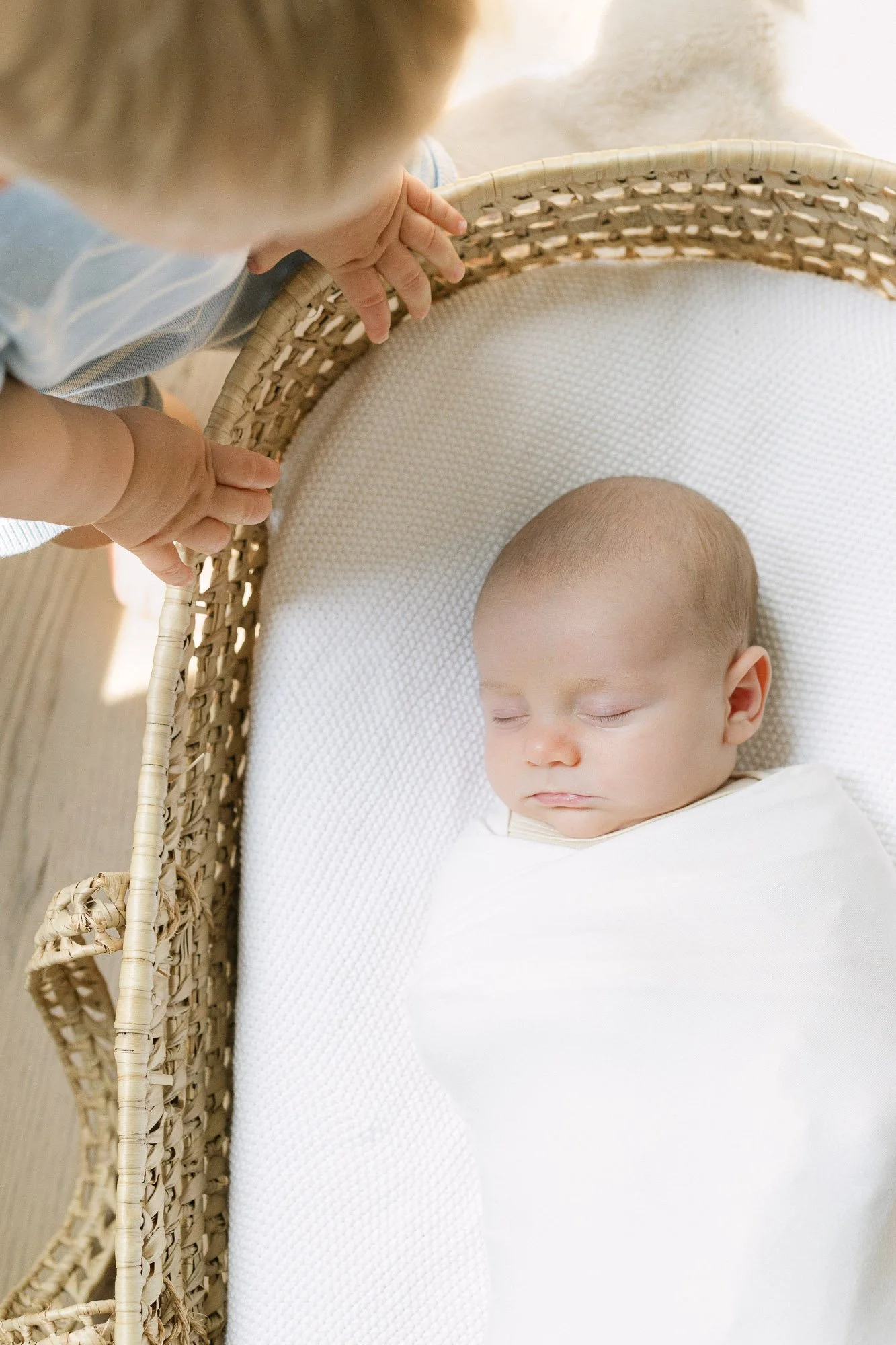 big brother peeking in on baby during an at home newborn photography session in Hinsdale