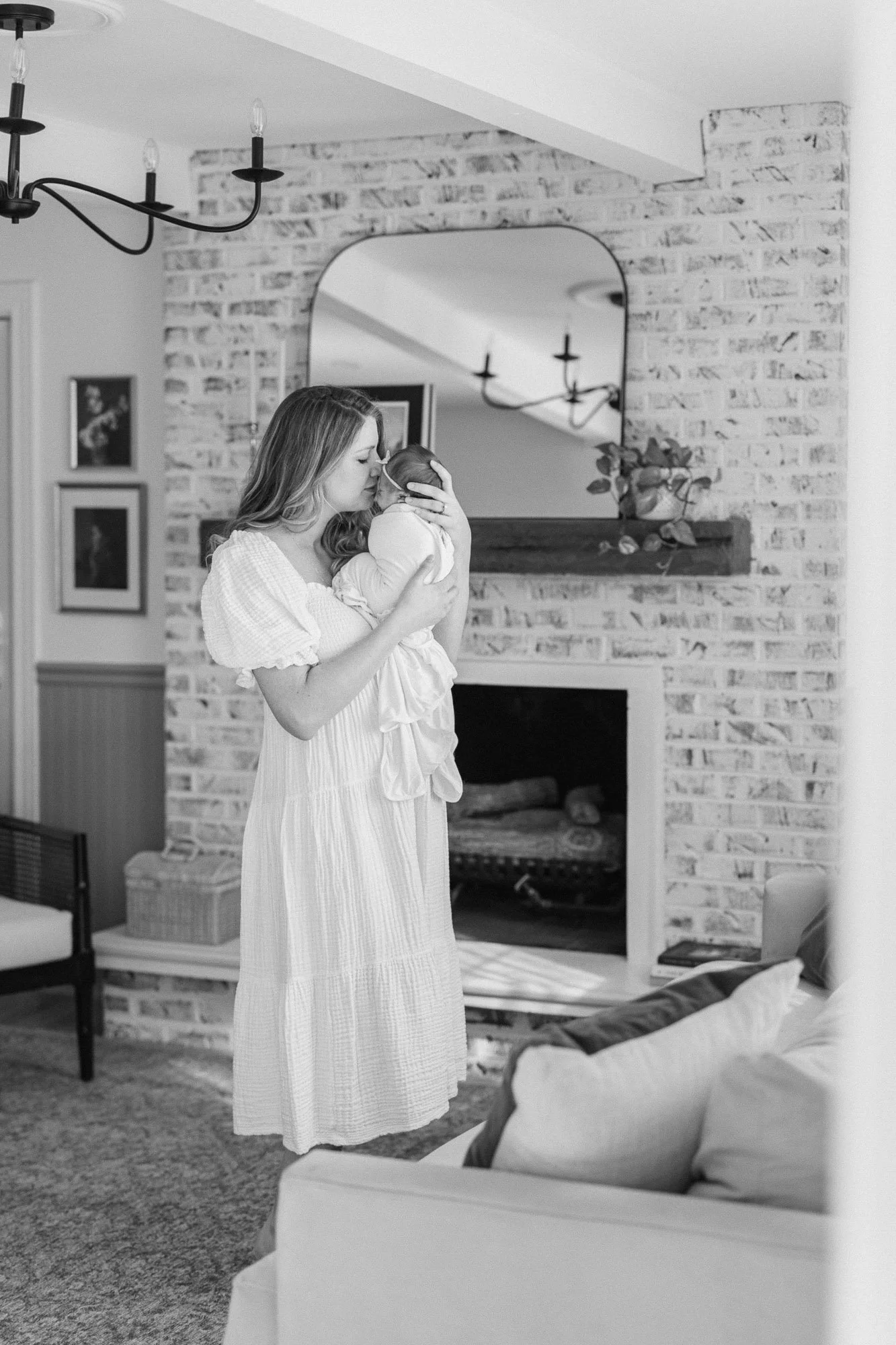 wide angle view of a mom tenderly snuggling her newborn baby girl during a home newborn session in Arlington Heights