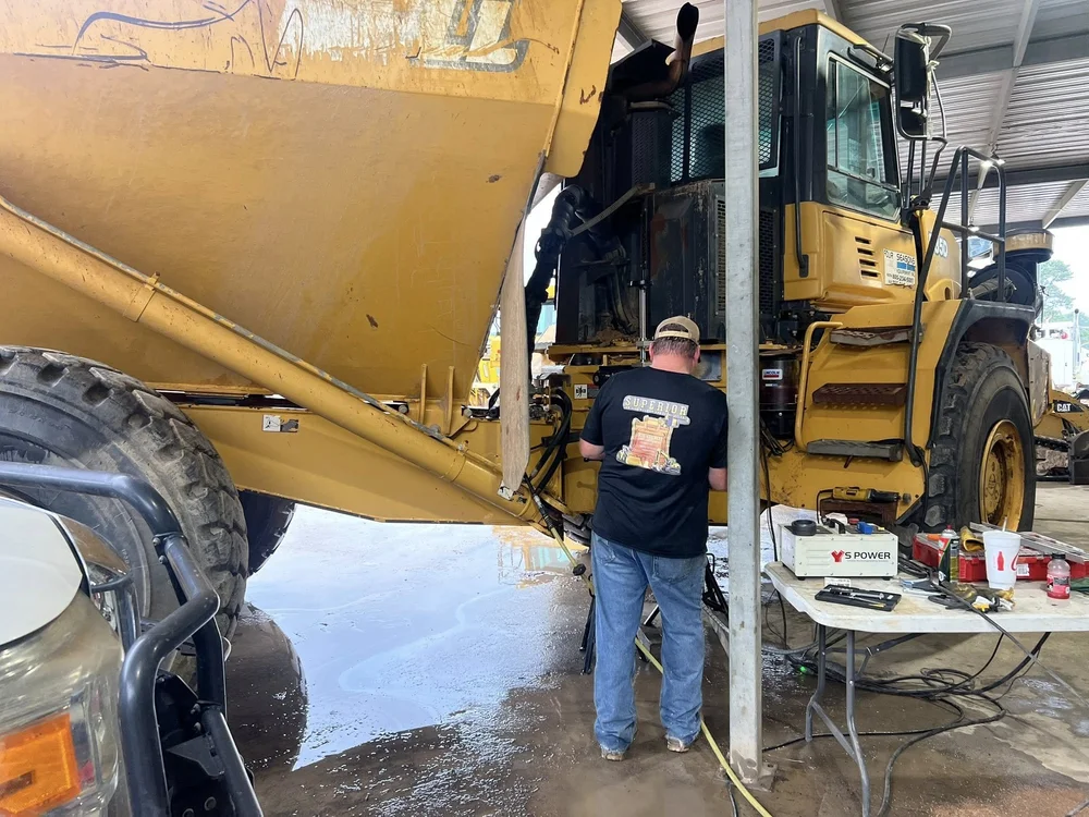 Superior team member working beside heavy machinery