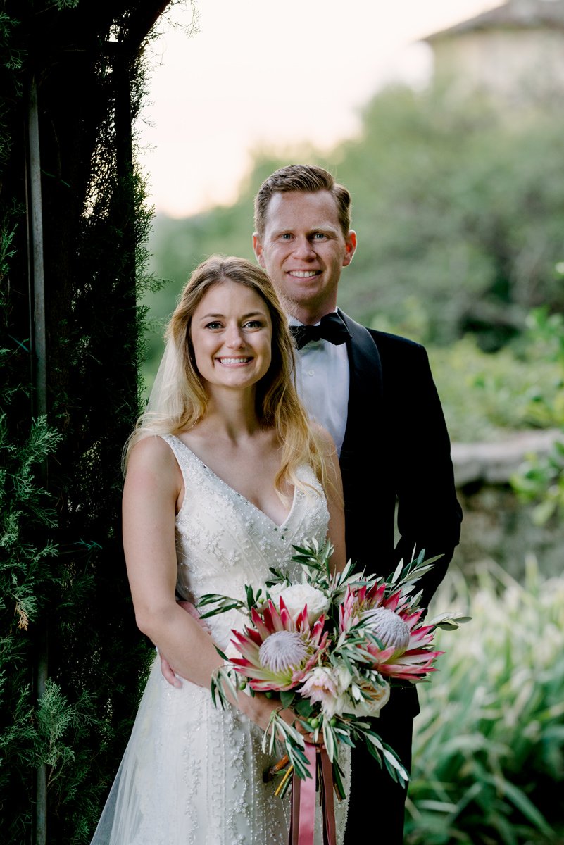 Portret van een stralend bruidspaar bij Castello di Montegufoni in Toscane – ontspannen moment tijdens een goed georganiseerde destination wedding met ceremoniemeester.