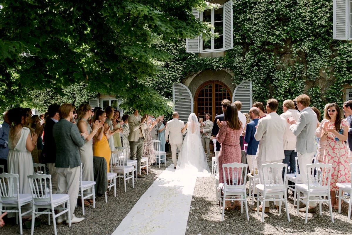 Bruid loopt met haar vader het gangpad af richting de ceremonie – een emotioneel moment tijdens een perfect getimede bruiloft met ceremoniemeester in Toscane.