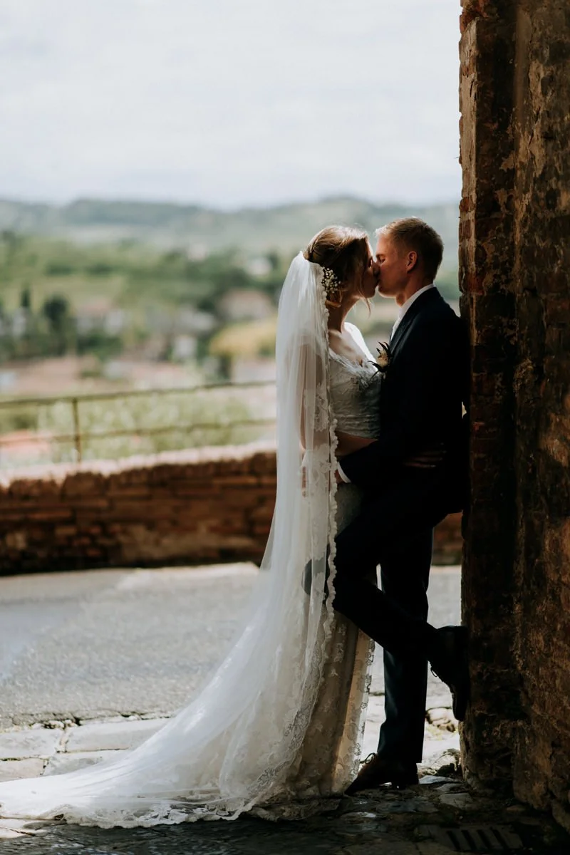 Bruidspaar kust elkaar in een sfeervol steegje bij nacht in Certaldo Alto – een intiem en tijdloos elopement moment in Toscane, vastgelegd door de trouwfotograaf van Toscane: FunkyBird Photography.