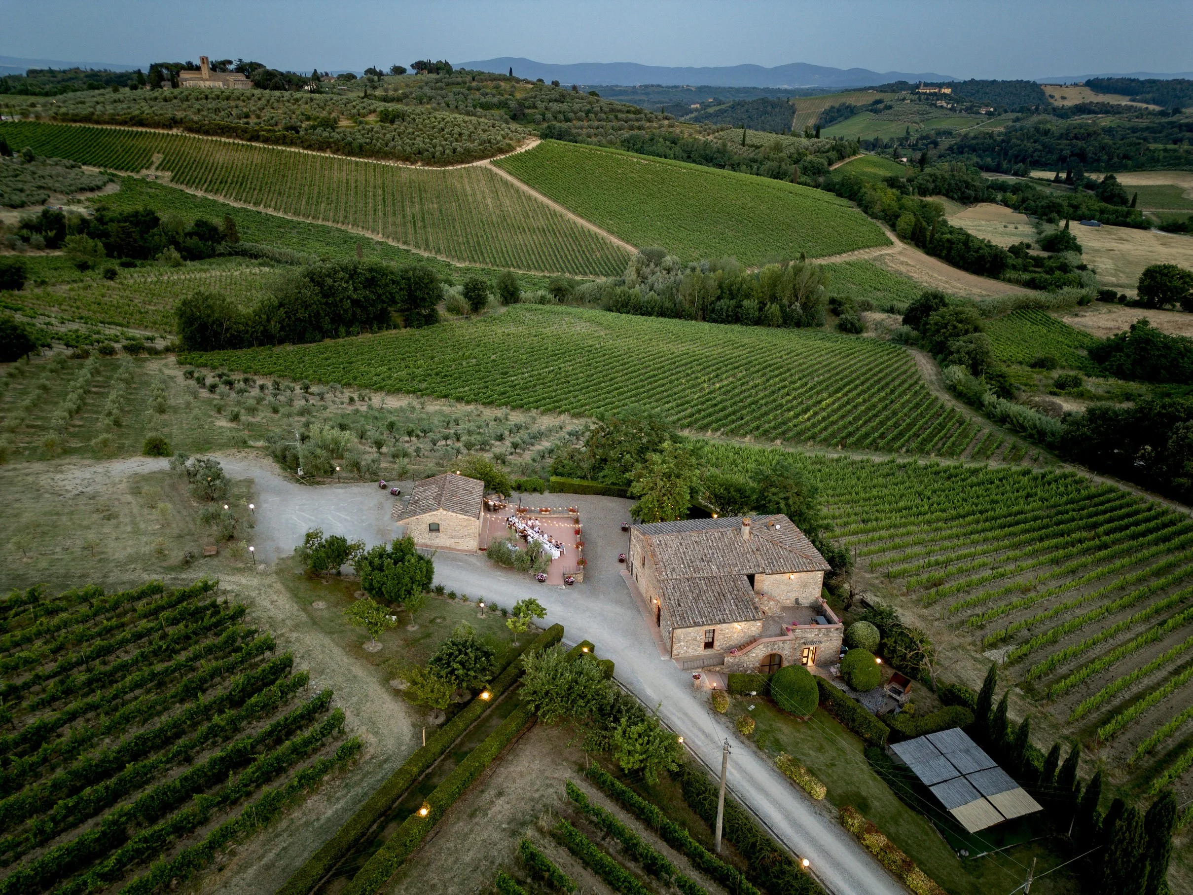 Dronebeeld van een trouwlocatie in Toscane, omringd door wijngaarden, dat laat zien hoe het landschap en de rust bijdragen aan de beleving van trouwen in Italië.