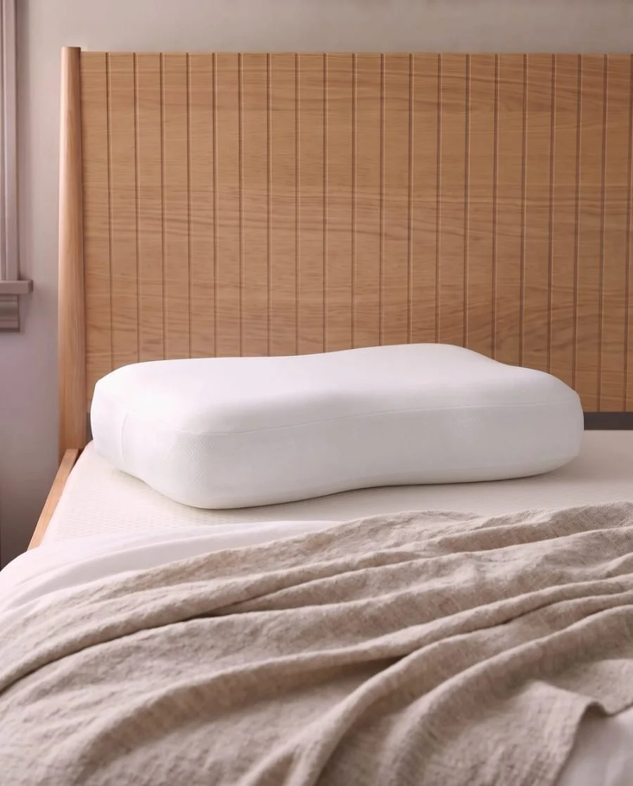 Ergonomic pillow on a bed, from Relax The Back