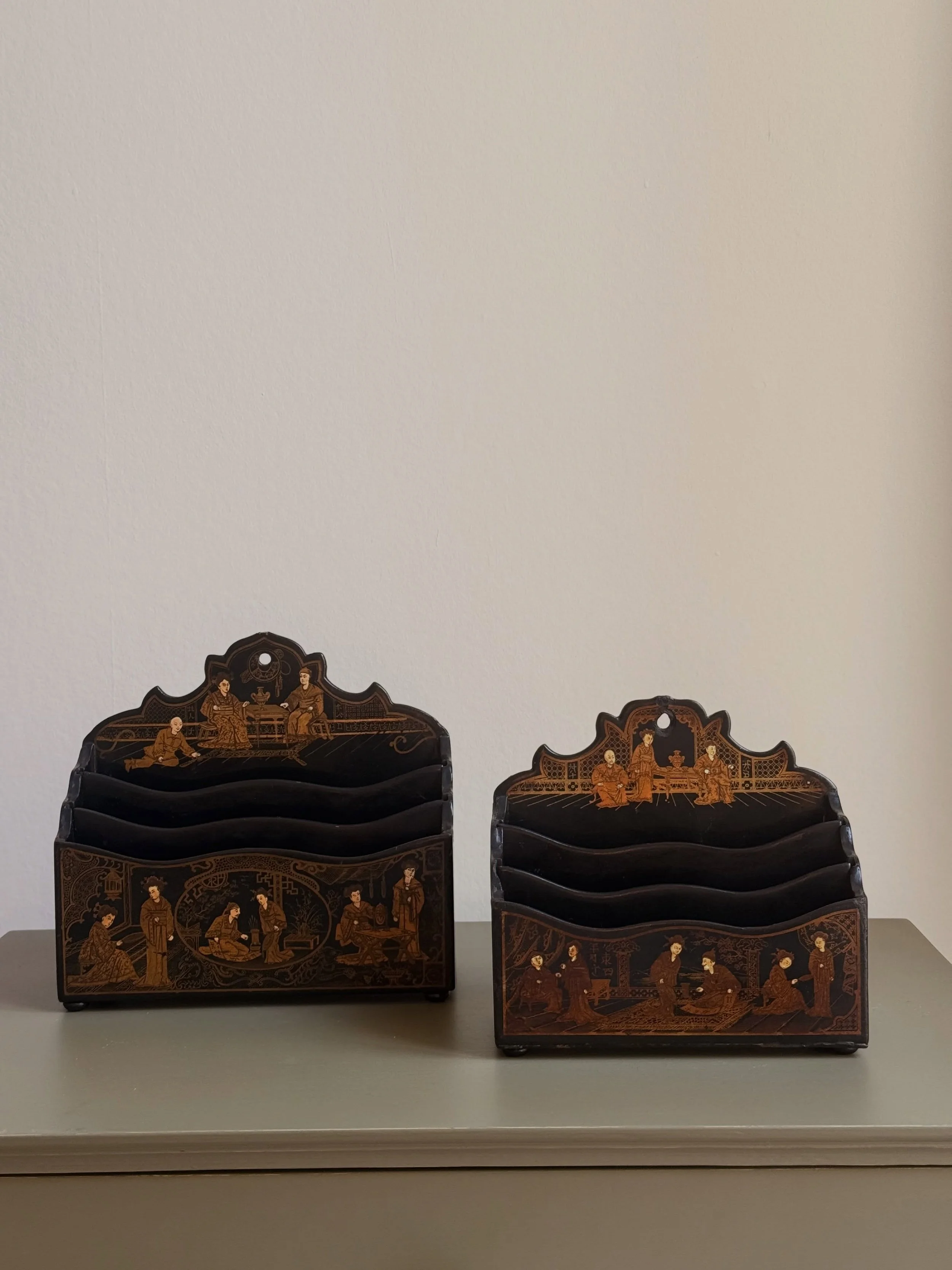 A charming pair of antique letter holders with finely detailed gilt chinoiserie decoration against a black ground.

Perfect for a desk, hallway or bedside table, and particularly lovely when paired with other antique writing accessories.

Wear to the