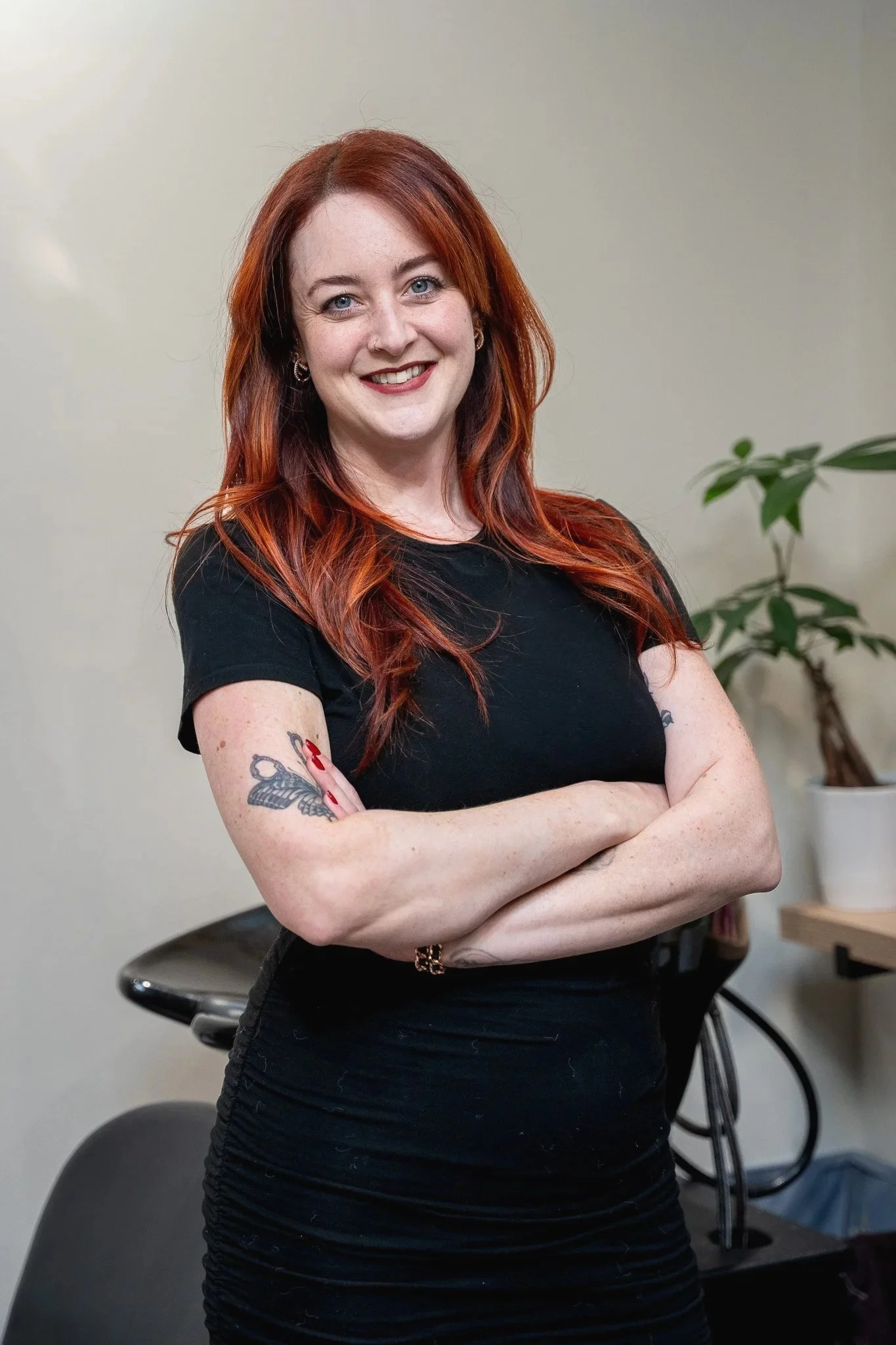 The owner of Laura Jayne Hairstylist, Laura Chavich, standing in her salon smiling.