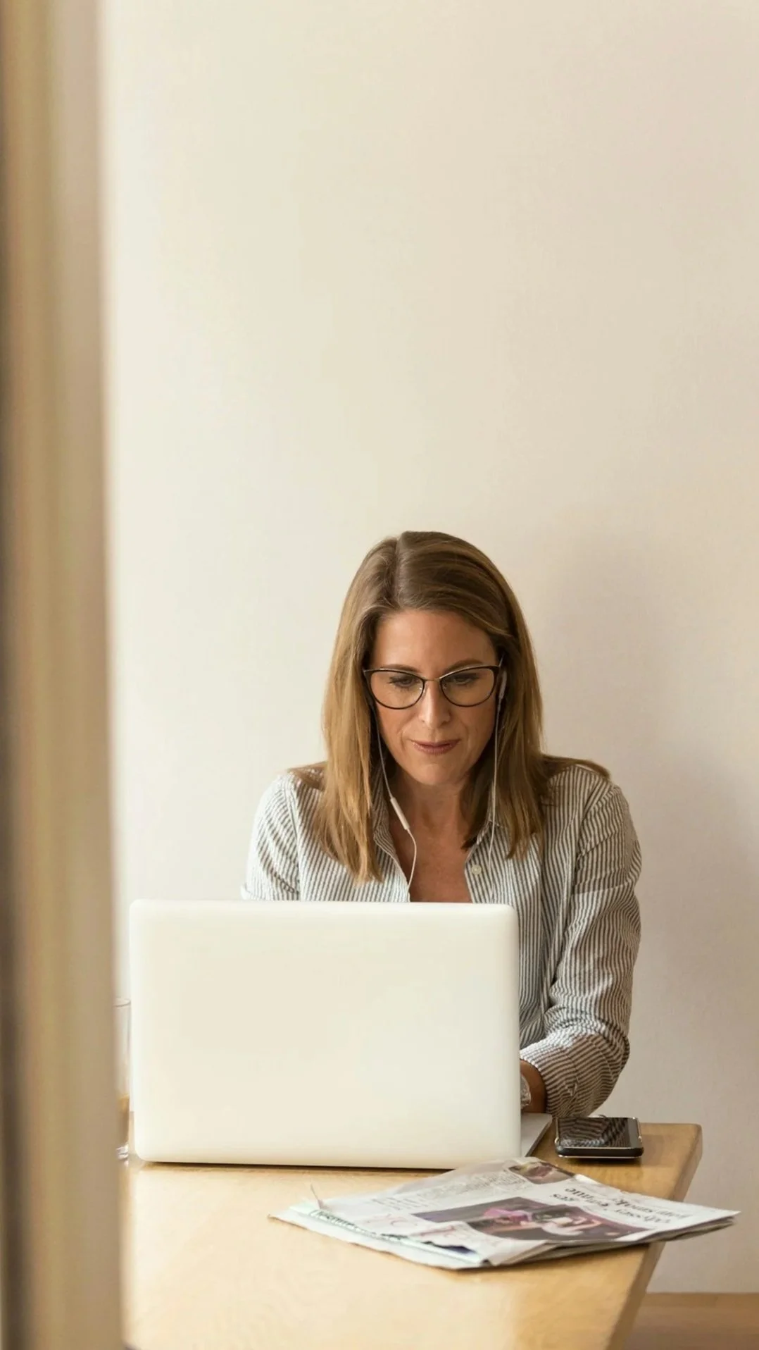 A woman with shoulder-length hair and beautiful blonde highlights working on her computer.