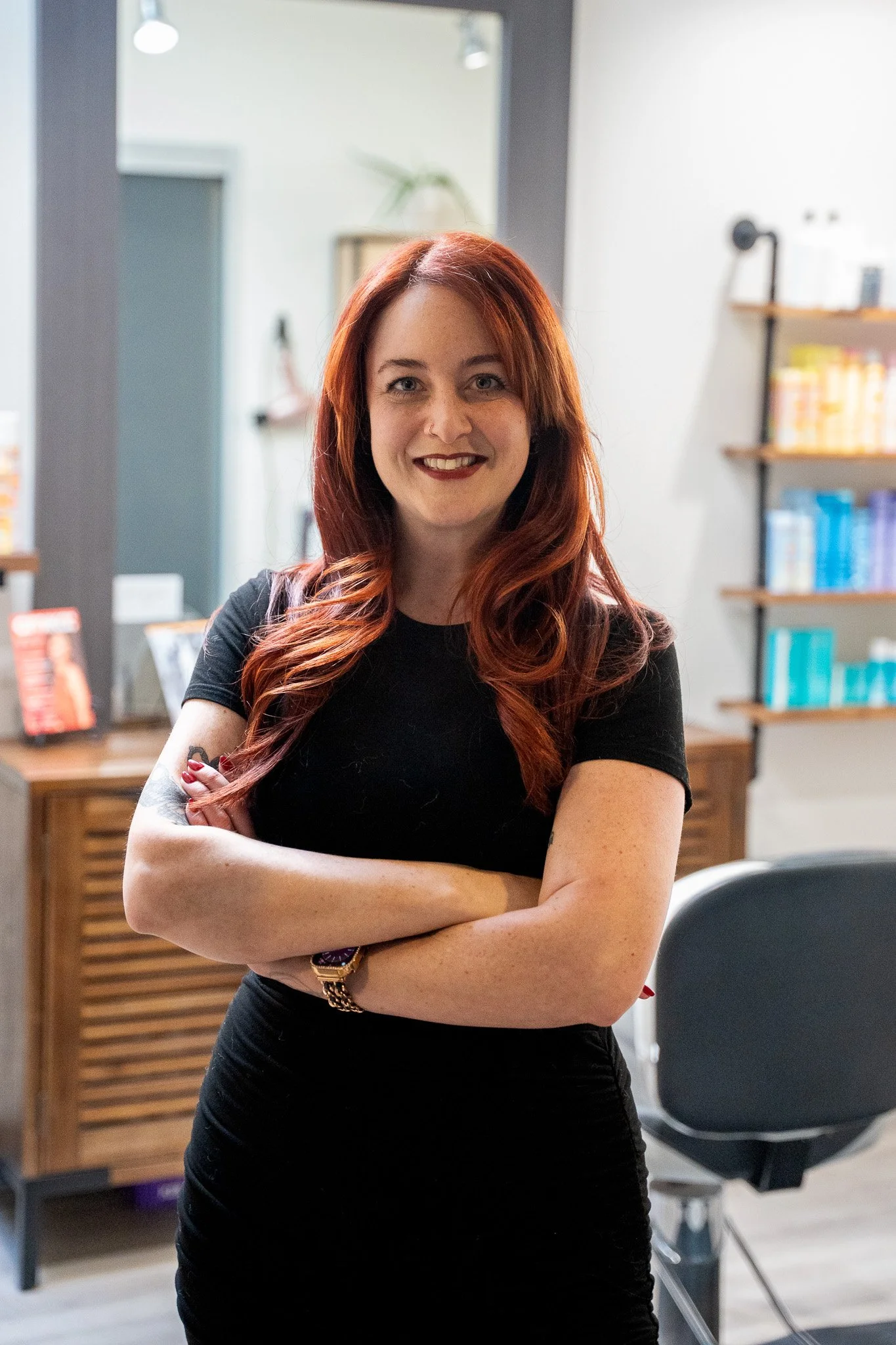 The owner, Laura Chavich, standing in the doorway of her salon, Laura Jayne Hairstylist, welcoming guests inside.