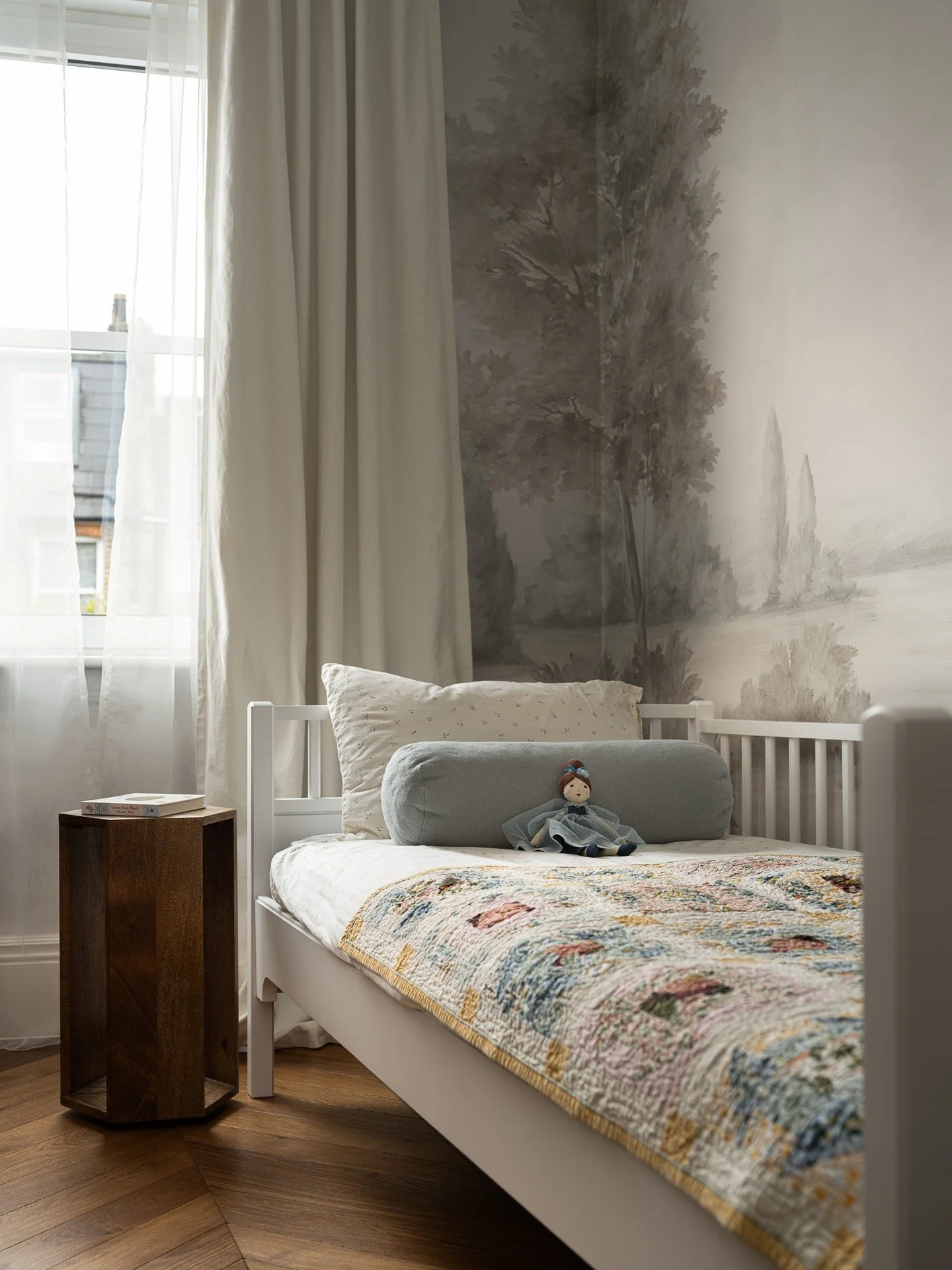 Parsons Green House 

A quiet corner designed for calm and imagination. The mural wallpaper by @susanhartermuralpapers sets a serene backdrop, while a handmade quilt &mdash; a birth gift for the room&rsquo;s young owner &mdash; adds warmth and meanin