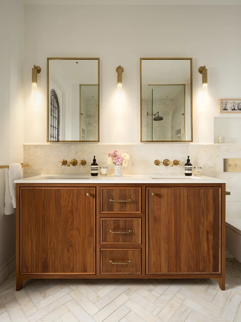 Parsons Green House

A balance of warmth and refinement &mdash; this bespoke walnut vanity anchors the master bathroom with quiet confidence. Calacatta Amber honed marble wraps the walls and skirting, its soft veining framed by a fine pencil edge det