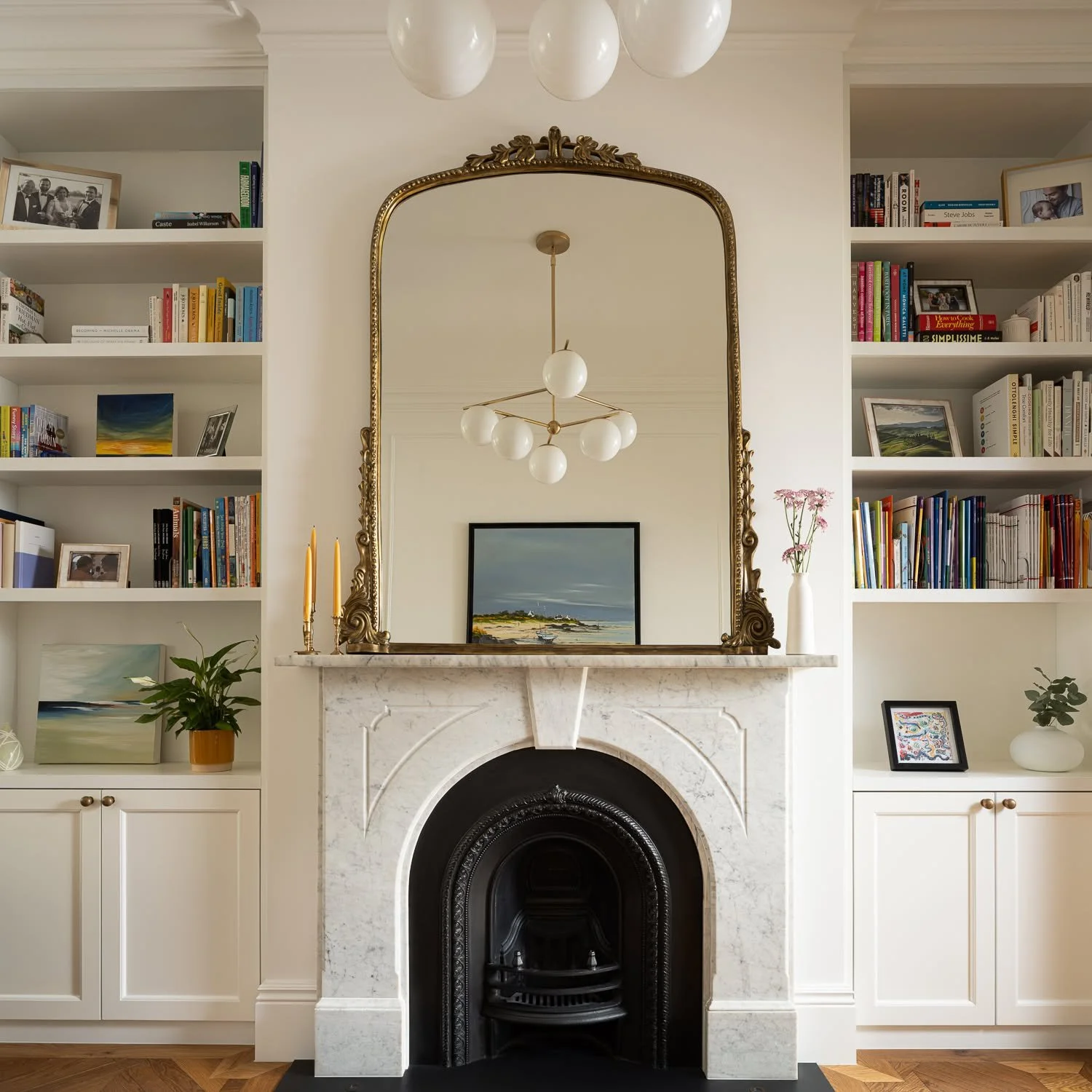 Parsons Green House | The Hearth 

Every room needs an anchor.

At Parsons Green, the living room organises itself around the original fireplace &mdash; restored marble surround, antique mirror above, and bespoke cabinetry flanking both sides. The bo