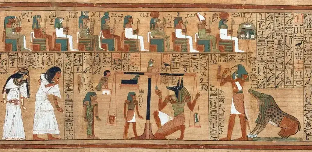 Ancient Egyptian papyrus showing the weighing of the heart in the afterlife, with Anubis beside the scales and hieroglyphs surrounding the ritual scene.