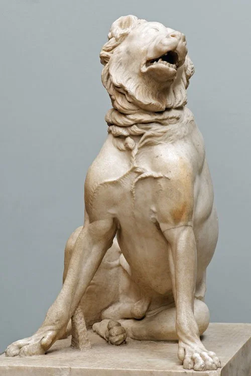 Ancient marble sculpture of a seated Molossian hound, known as the Jennings Dog, with detailed fur and muscular form, displayed on a stone base.