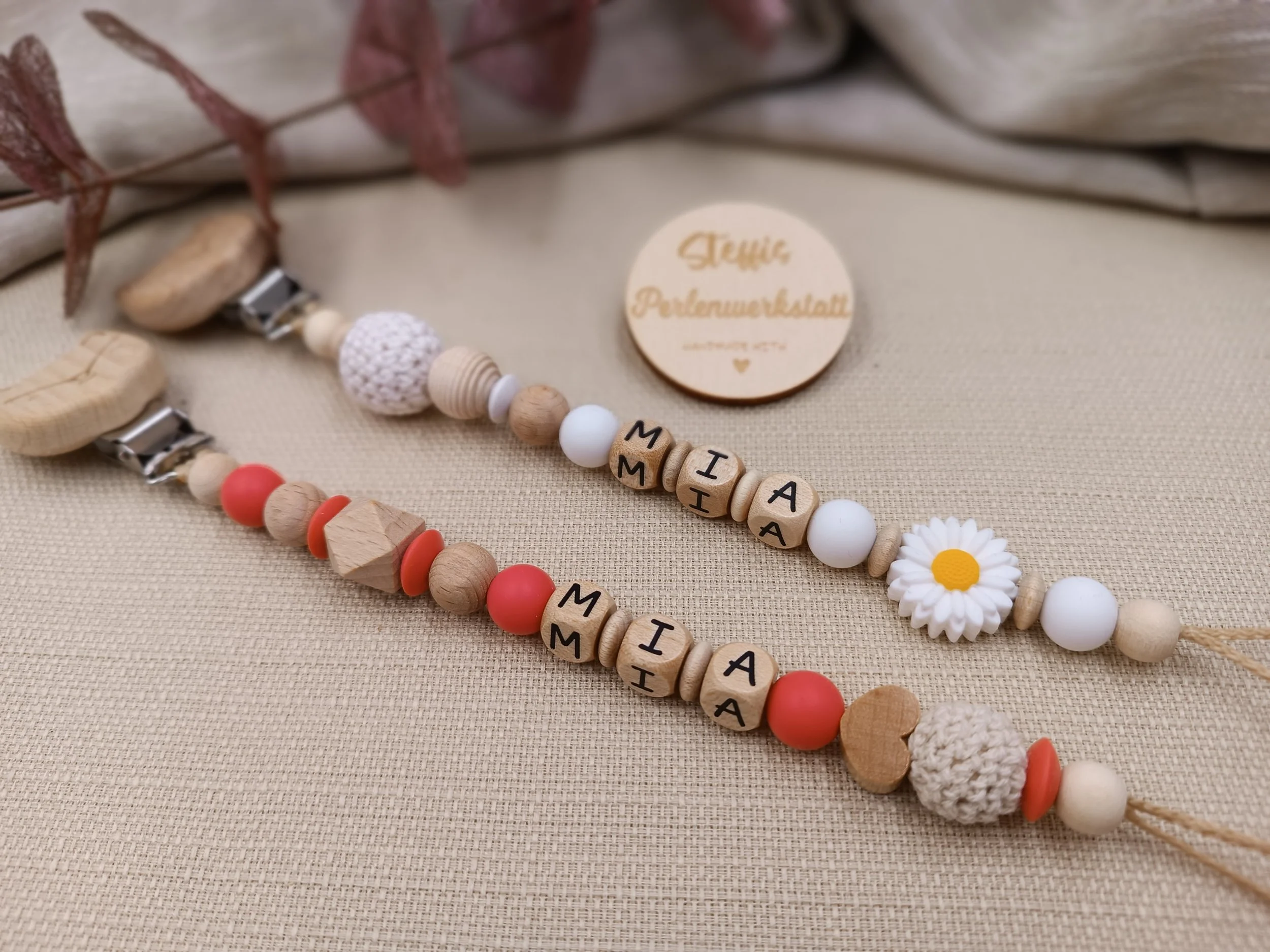 Schnullerketten Set personalisiert mit Holzbuchstaben,
bestehend aus Holz,- Silikon- und Häkelperlen.
Motivperle Blume in weiß
Motivperle Herz in rot (neu).
Preis je 17 Euro