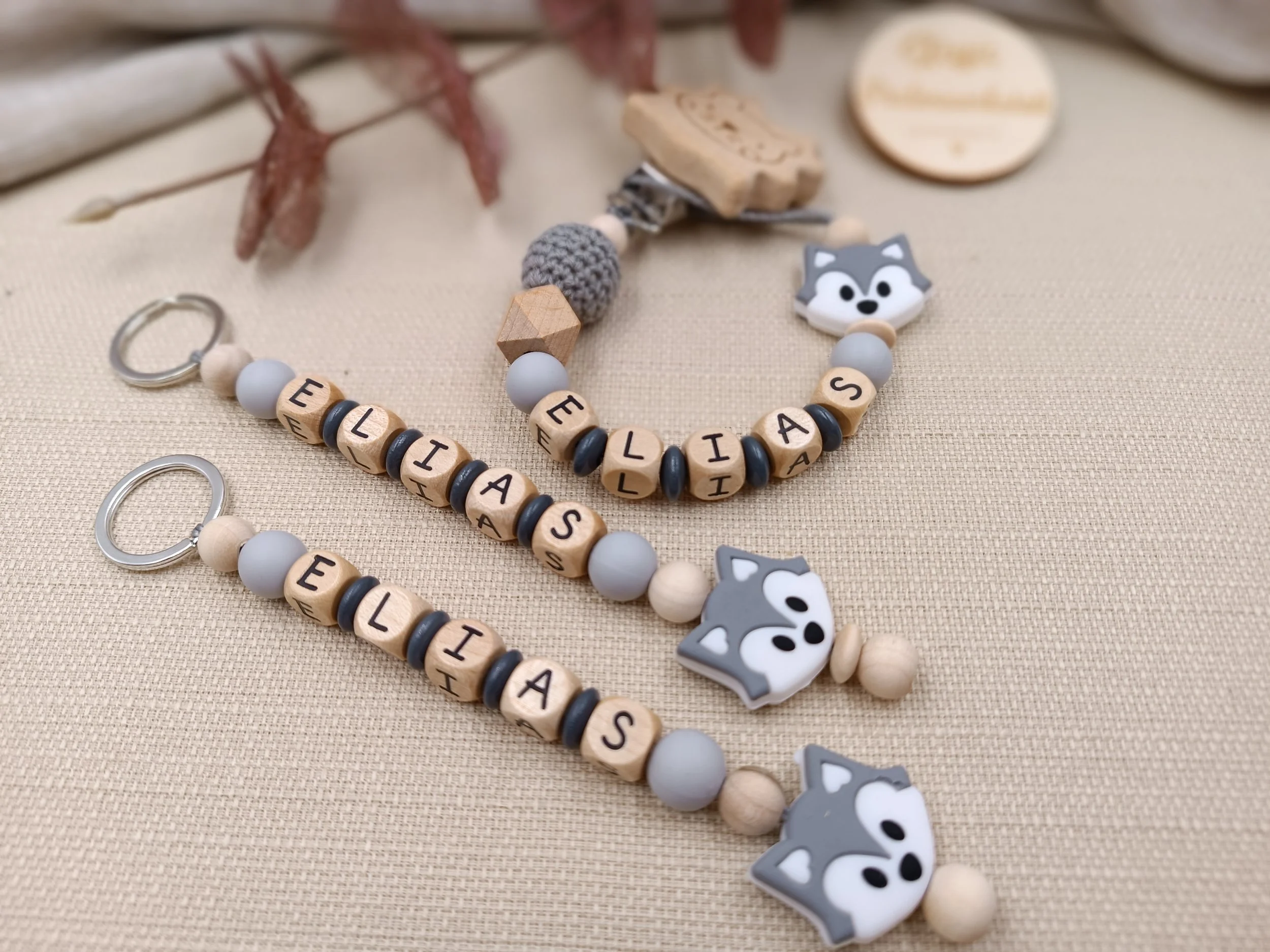 Schnullerkette in Kombi mit zwei Schlüsselanhänger, personalisiert mit Holzbuchstaben,
bestehend aus Holz,- Silikon- und Häkelperlen.
Motivperle "Fuchs" in grau
Preis ab 35 Euro