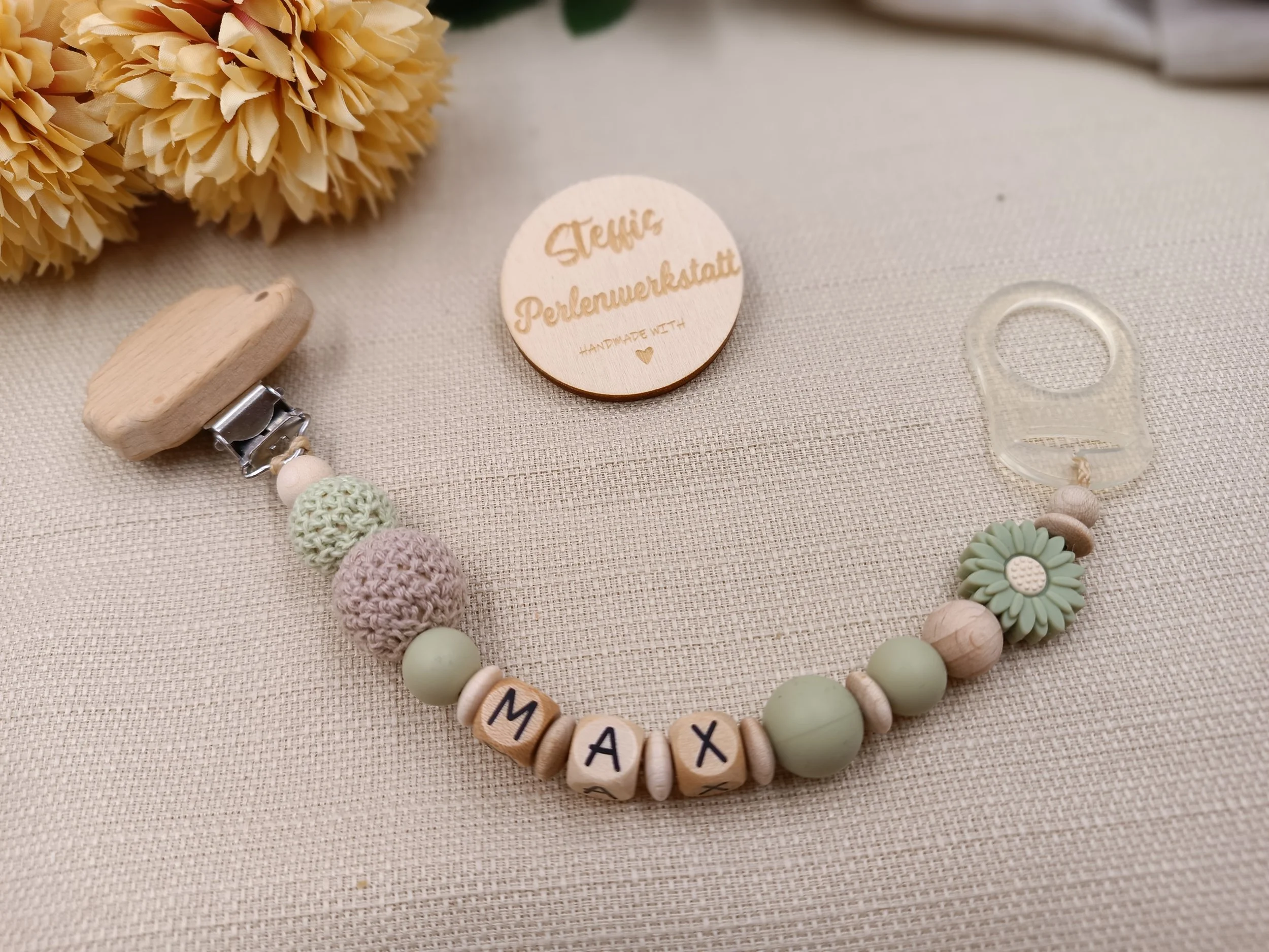 Schnullerkette personalisiert mit Holzbuchstaben,
bestehend aus Holz,- Silikon- und Häkelperlen und Adapter
Preis 18 Euro je nach Länge des Namens