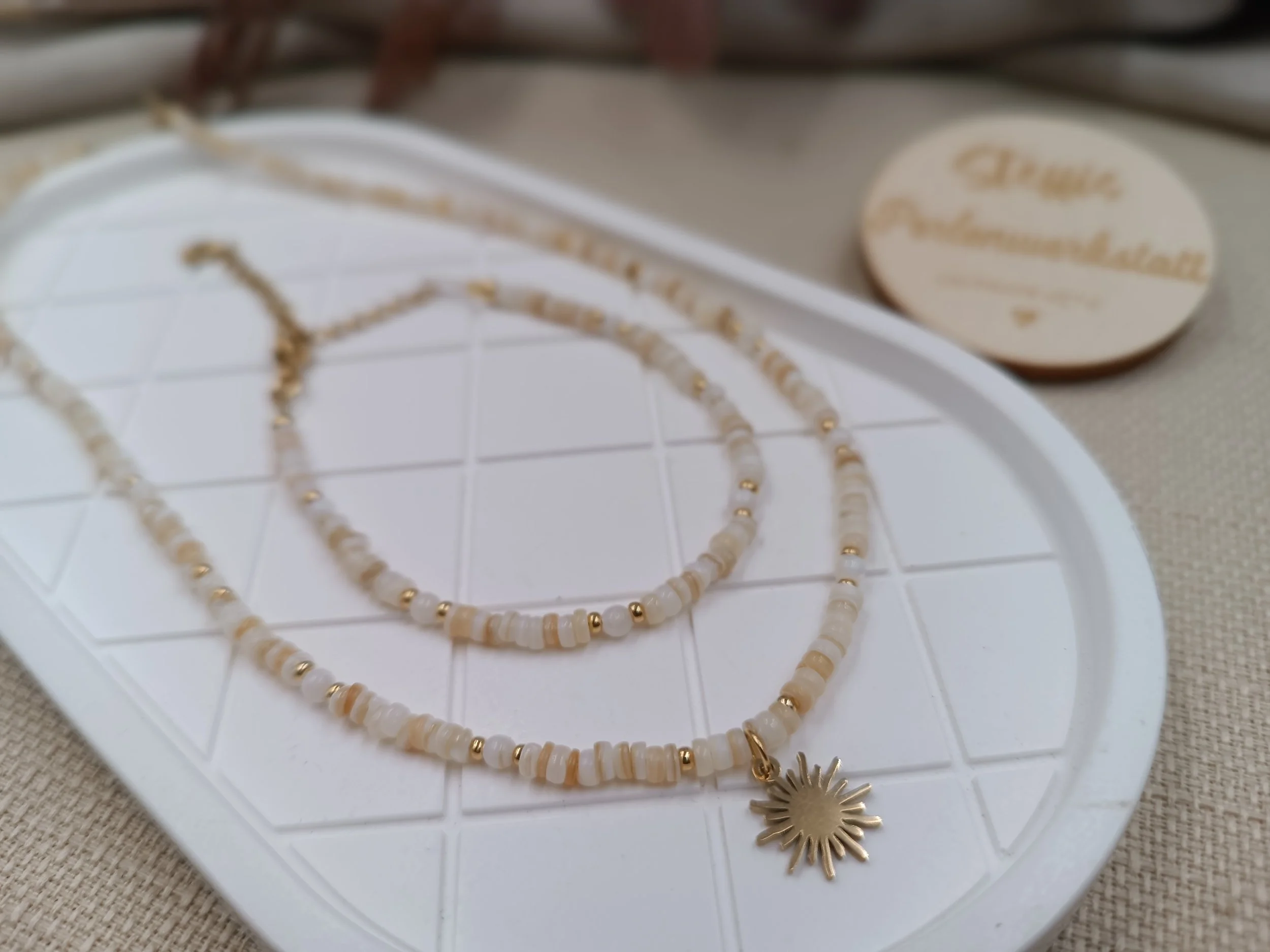 Set aus Armband & Halskette bestehend aus 3mm Muschelperlen.
Anhänger "Sonne" aus Edelstahl
Preis Kette: 23 Euro
Preis Armband: 15  Euro
