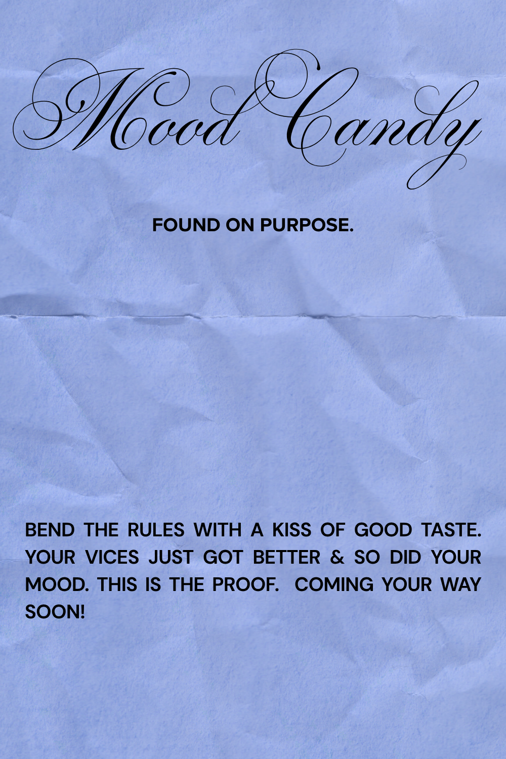 A crumpled light blue piece of paper with the words "Mood Candy" written in elegant cursive font and the phrase "Found on purpose." in bold, followed by a paragraph of encouraging text in bold about changing one’s mood.