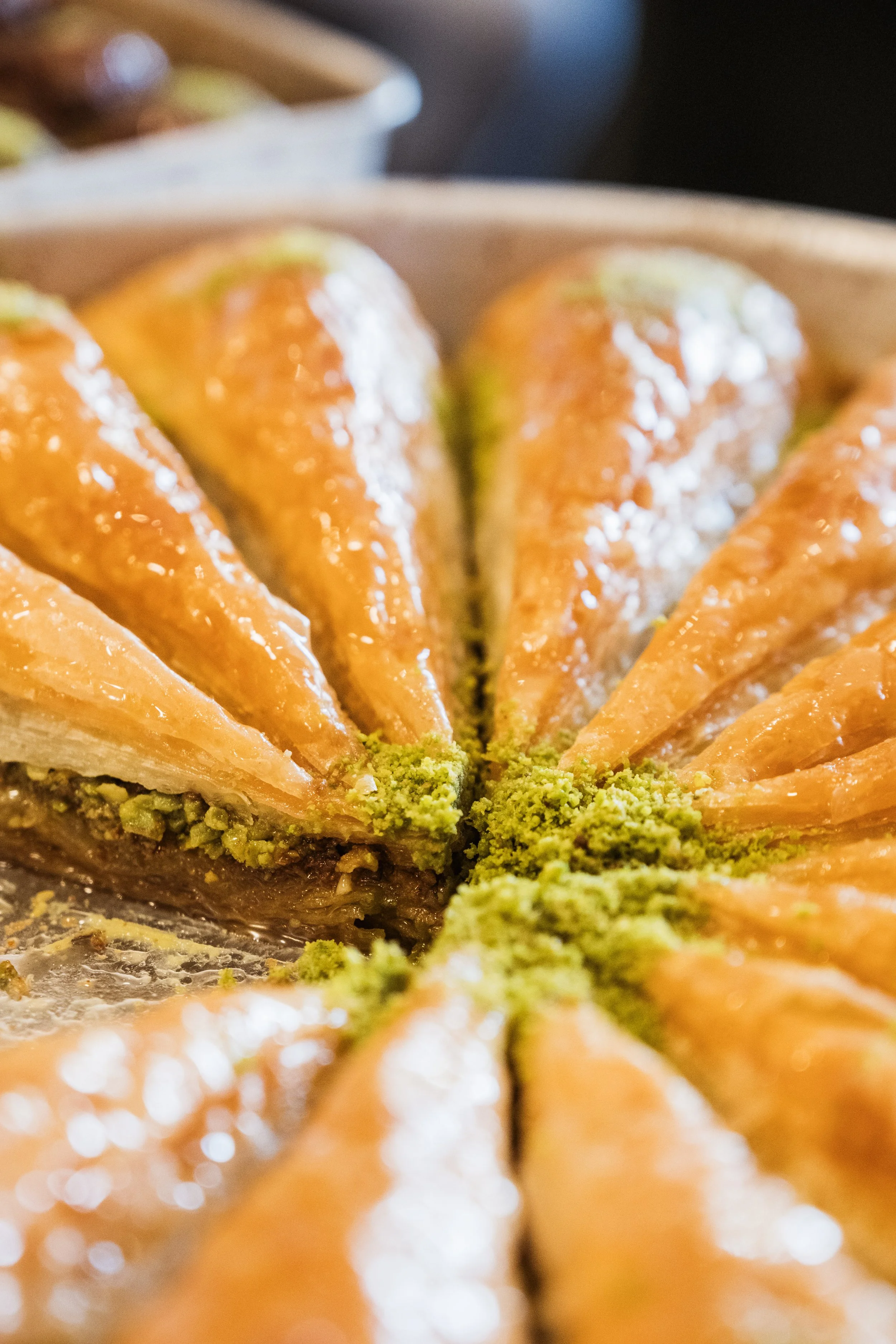 Close-up of a sliced pie with orange filling and green pistachio crumbs on top.
