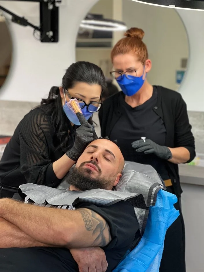 HeadSkin Coloring Behandlung bei einem Mann mit lichter Kopfhaut im Schulungszentrum für professionelle Kopfhautpigmentierung