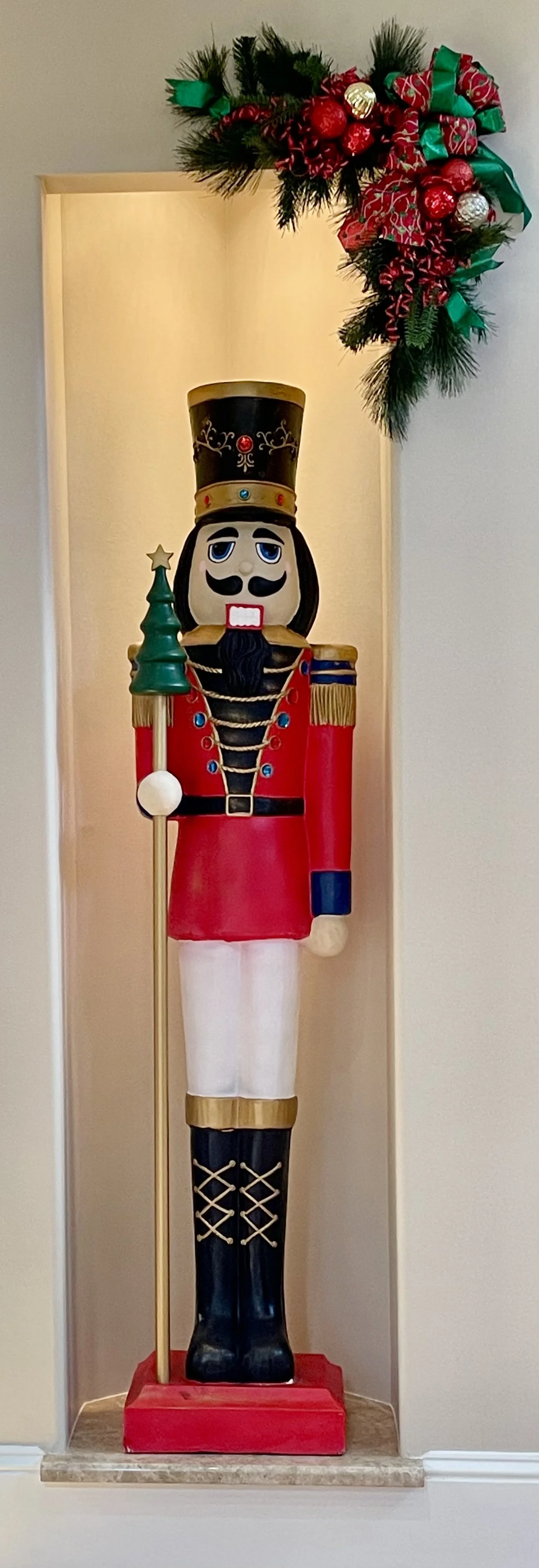 A life-sized nutcracker as part of holiday decor in a home; crafted by Design & Gather.