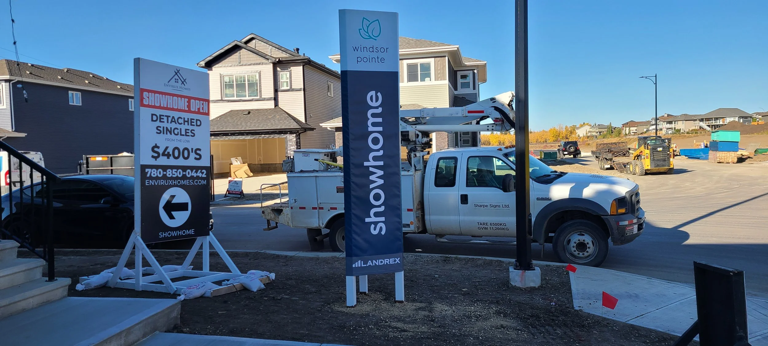 Construction site with signage advertising a show home opening.