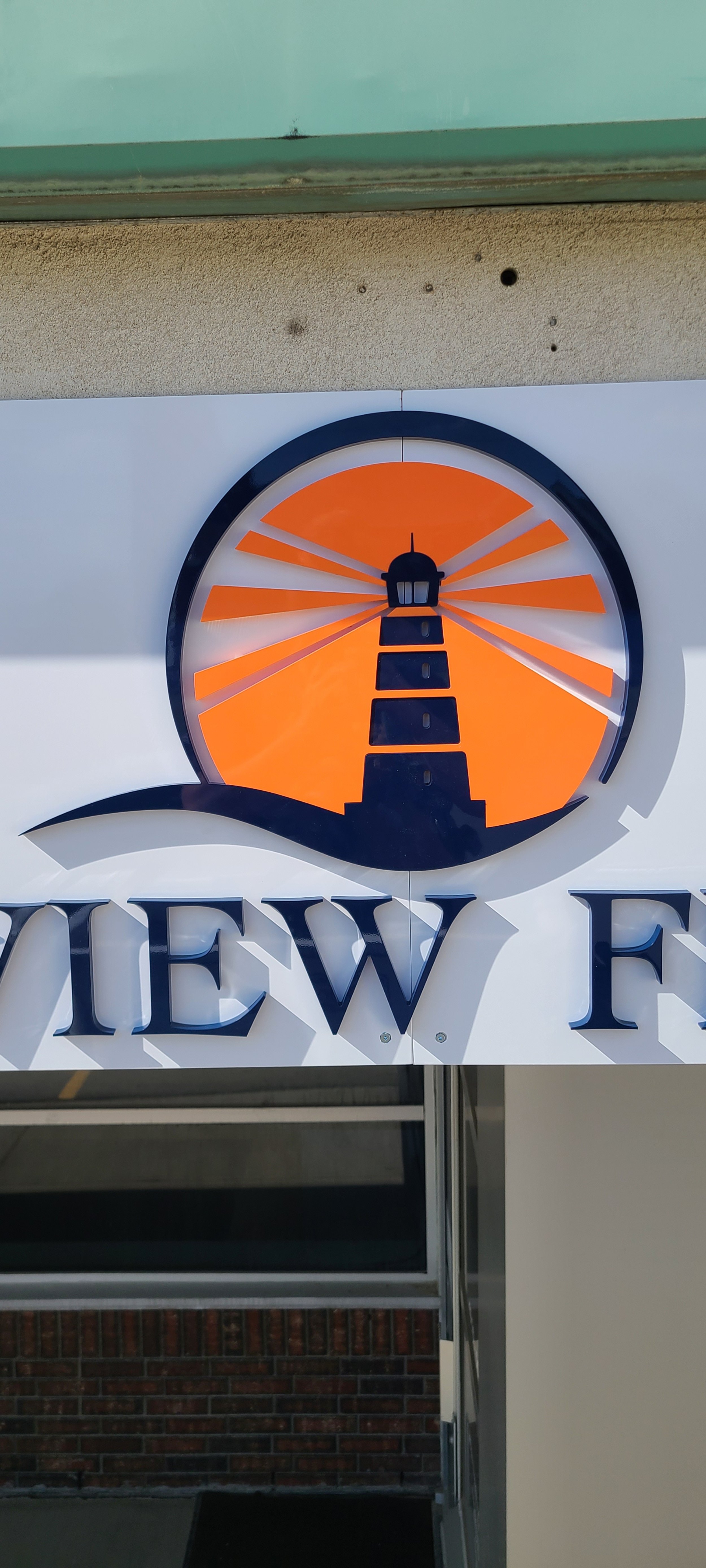 Sign featuring a lighthouse silhouette with an orange background 