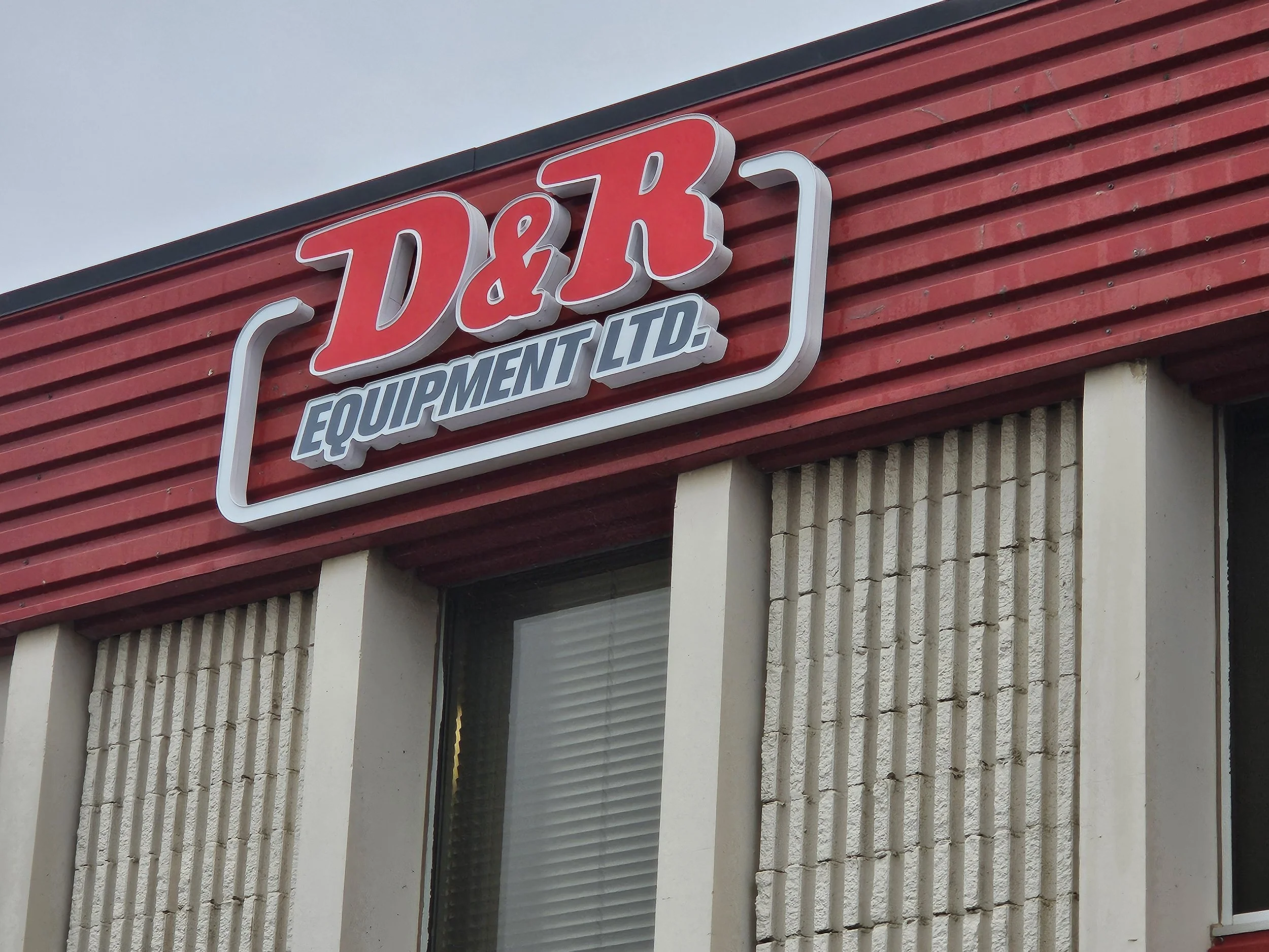 Sign on a red building that reads 'D&J Equipment Ltd.'