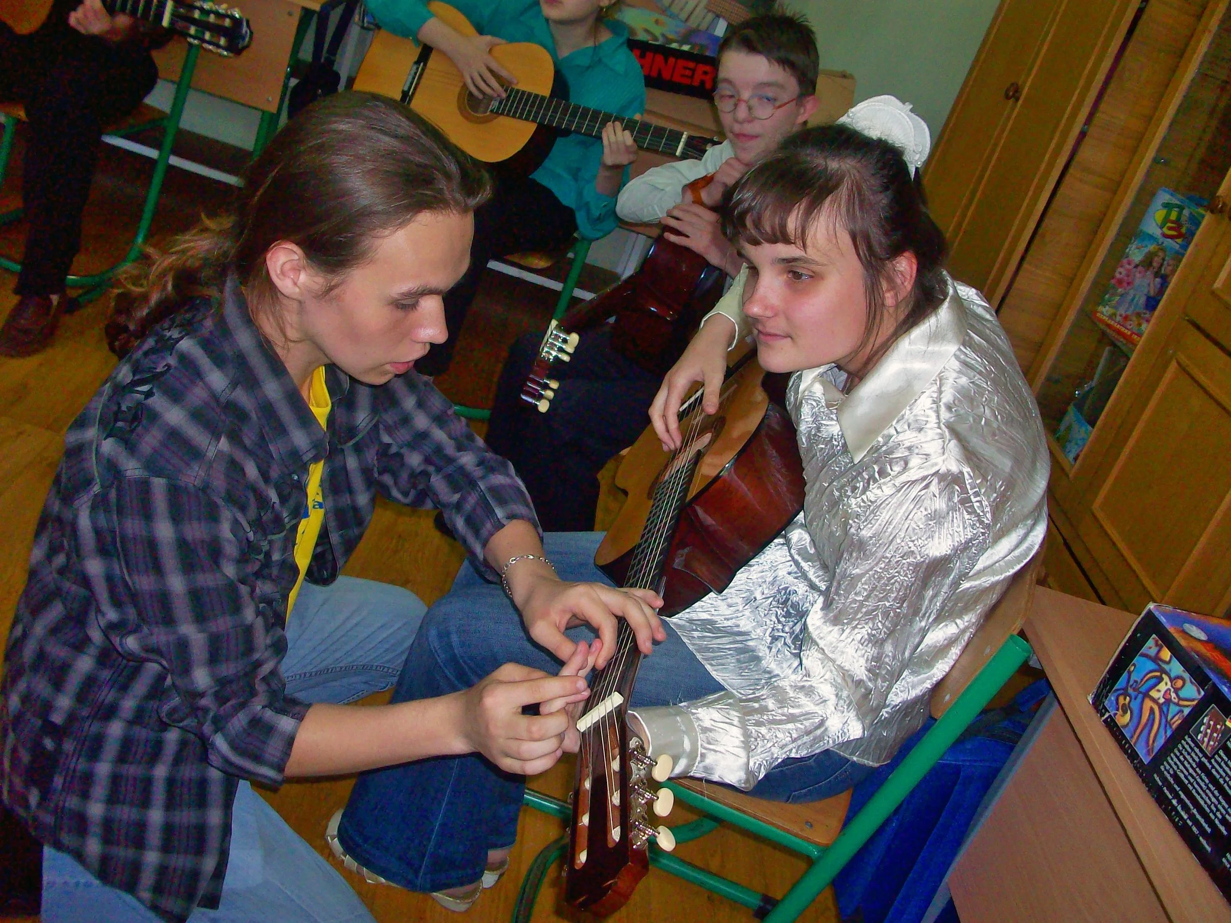 Oleg helps Lilia feel the guitar strings.JPG