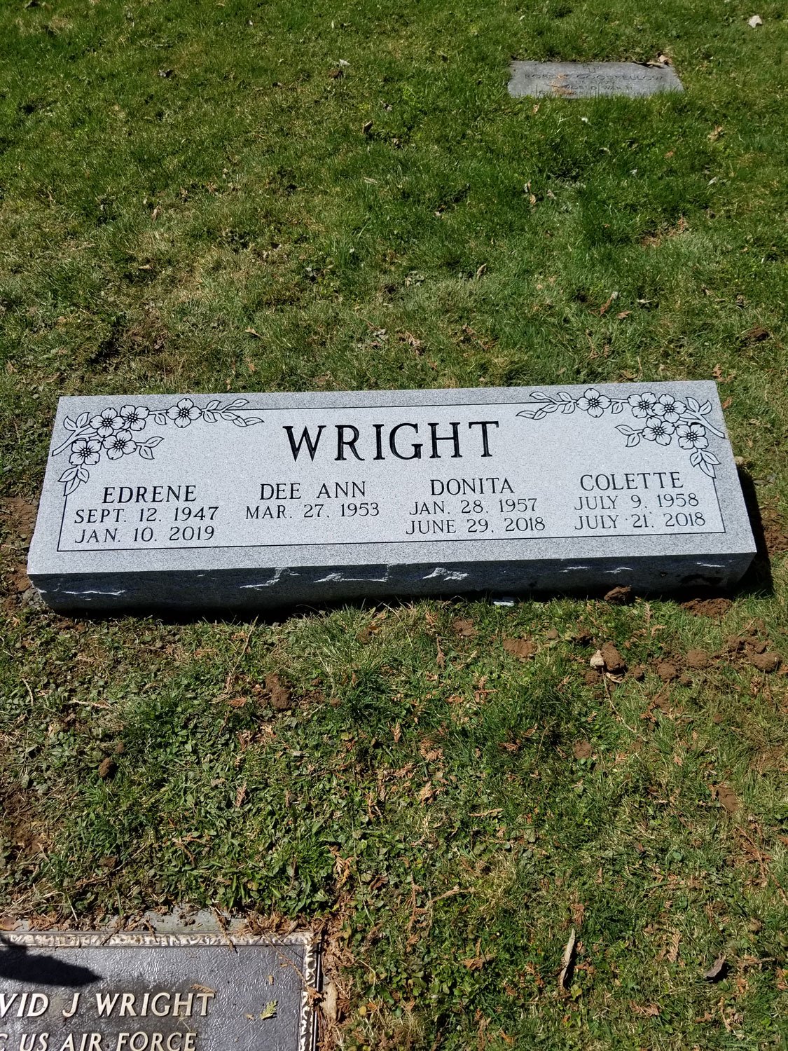 Gravestone for the Wright family, with floral decorations, listing four names and their birth and death dates.