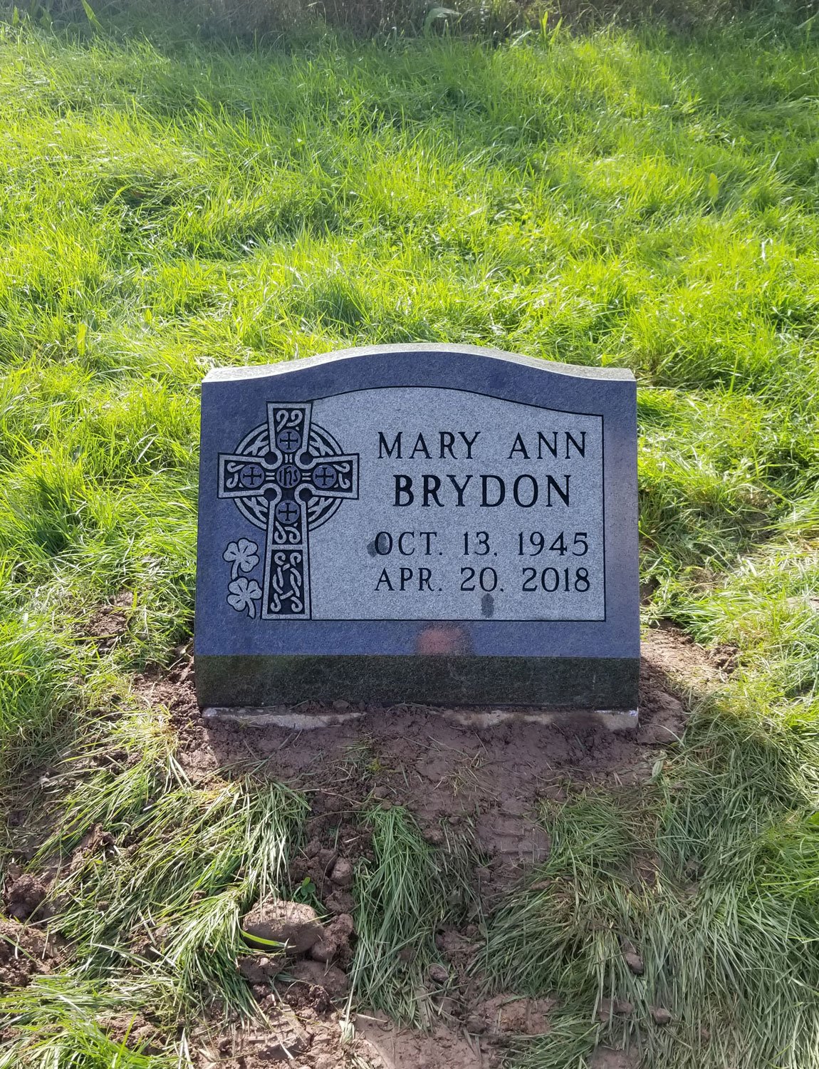 Gravestone for Mary Ann Brydon with a Celtic cross and shamrocks, dated October 13, 1945, died April 20, 2018, in a grassy cemetery.