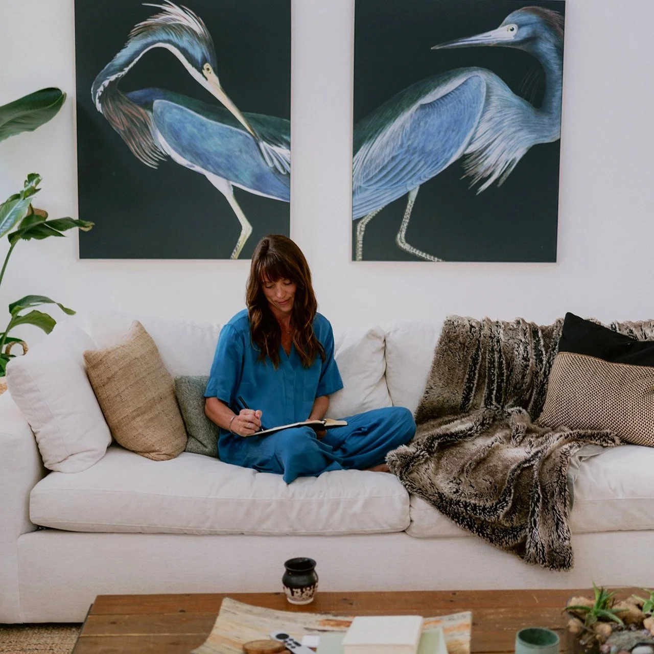 Brandi sitting on the couch writing in journal - Blog, articles, and resources for intentional living