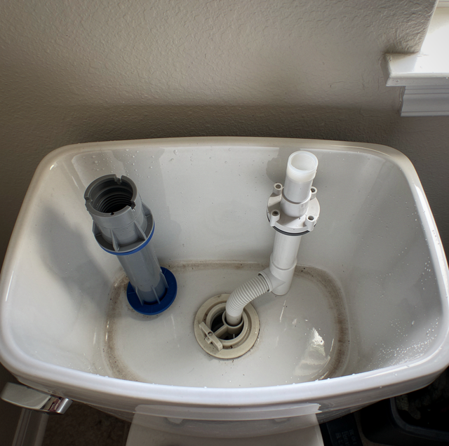 open toilet tank showing fill valve and flapper
