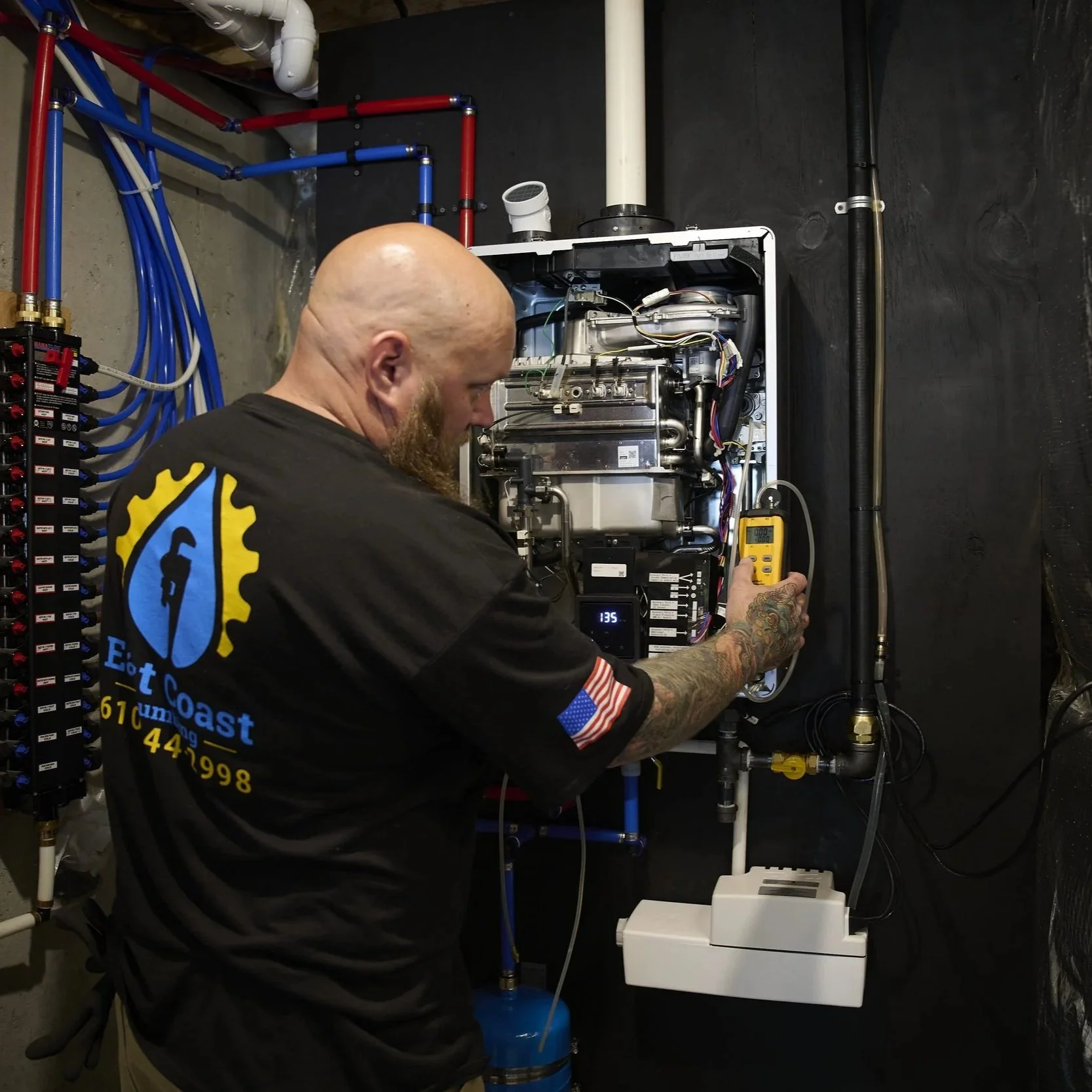 Plumber diagnosing a tankless water heater with testing equipment, investigating performance issues and unusual operating noises indoors.