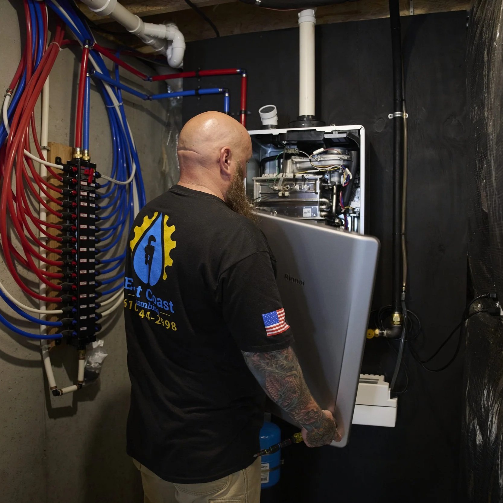 Technician installing tankless water heater with gas and water connections, highlighting professional setup factors that influence installation costs and performance.