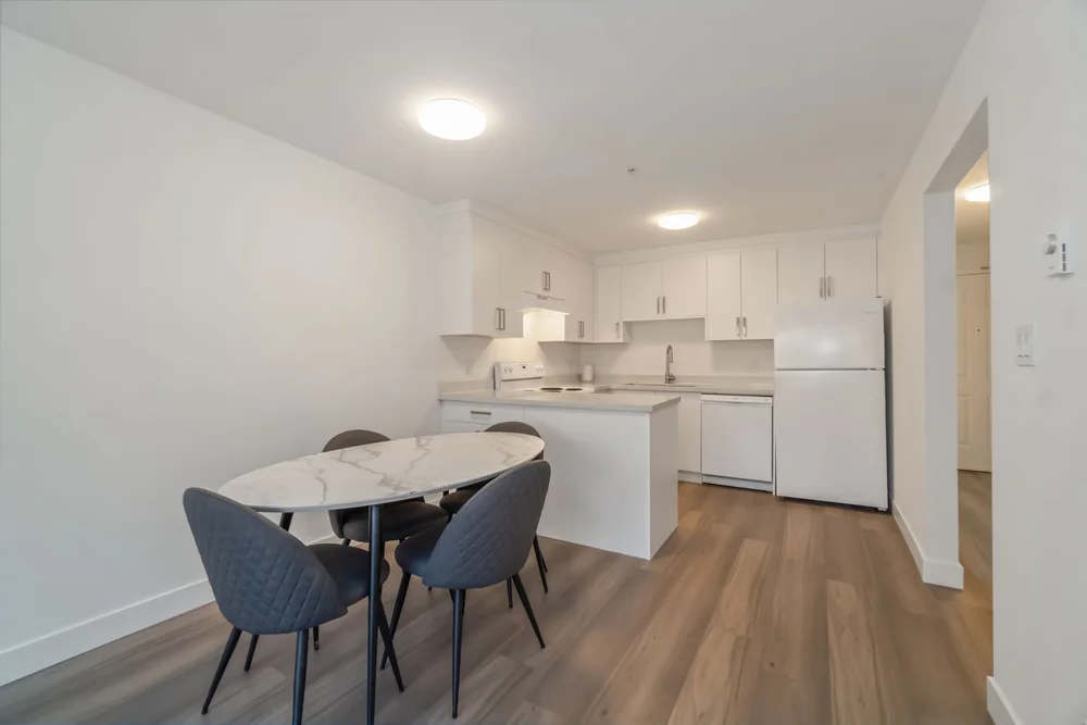 Staged dining table with kitchen island behind, bright natural light