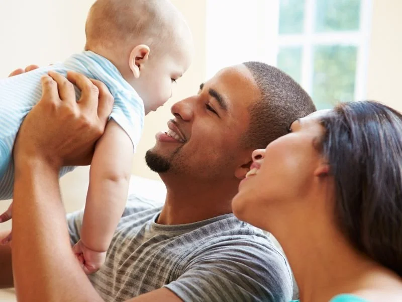 Family with life insurance in Redding holding up their newborn baby