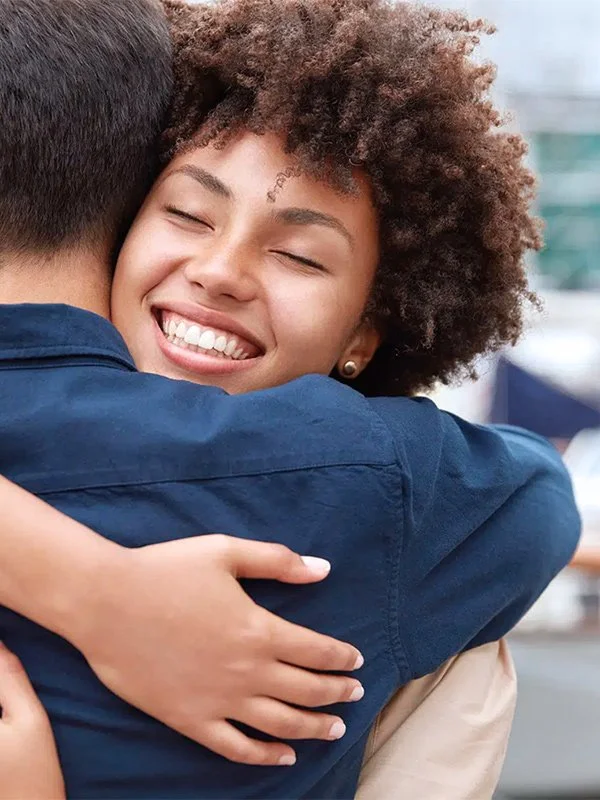 Couple hugging protected by life insurance with insurance agent in Redding