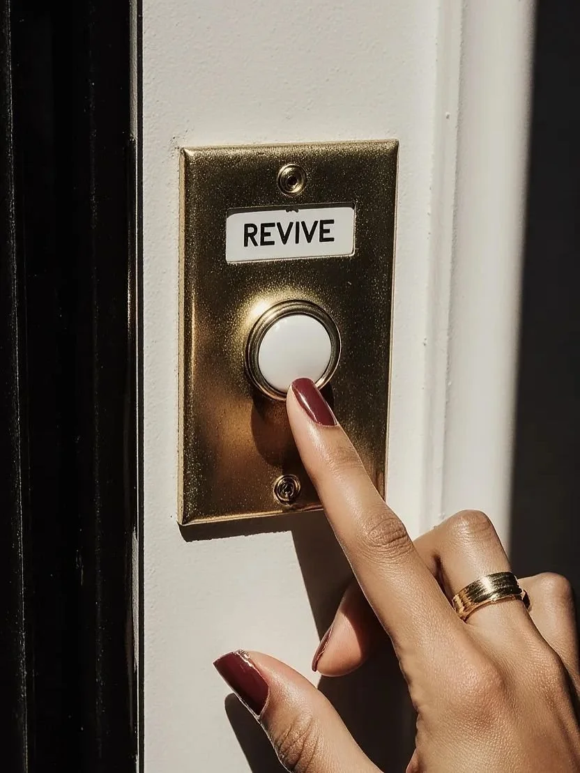 Close-up of a woman's hand with red nail polish and a gold ring pressing the emergency revive button on a wall switch plate.