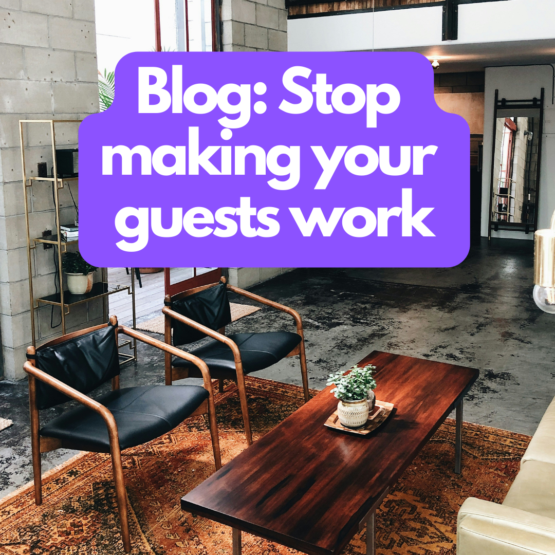 A modern interior of a lounge with a marble block wall, a wooden coffee table with a potted plant, black armchairs with wooden frames, and a decorative rug. The text overlay says "Blog: Stop making your guests work" in bold white letters on a purple 
