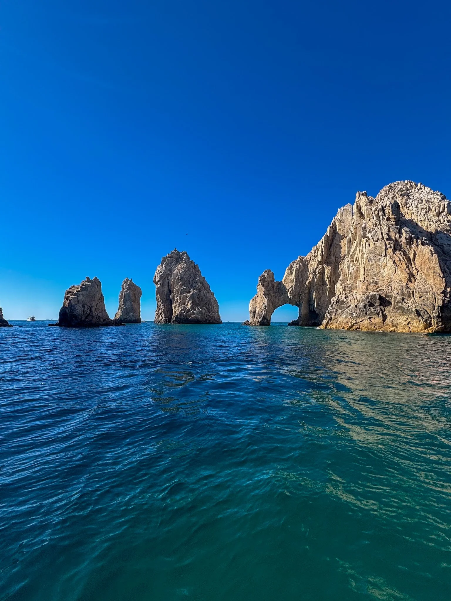 Sea with large rocky formations and natural arches under a clear blue sky in Cabo San Lucas Mexico