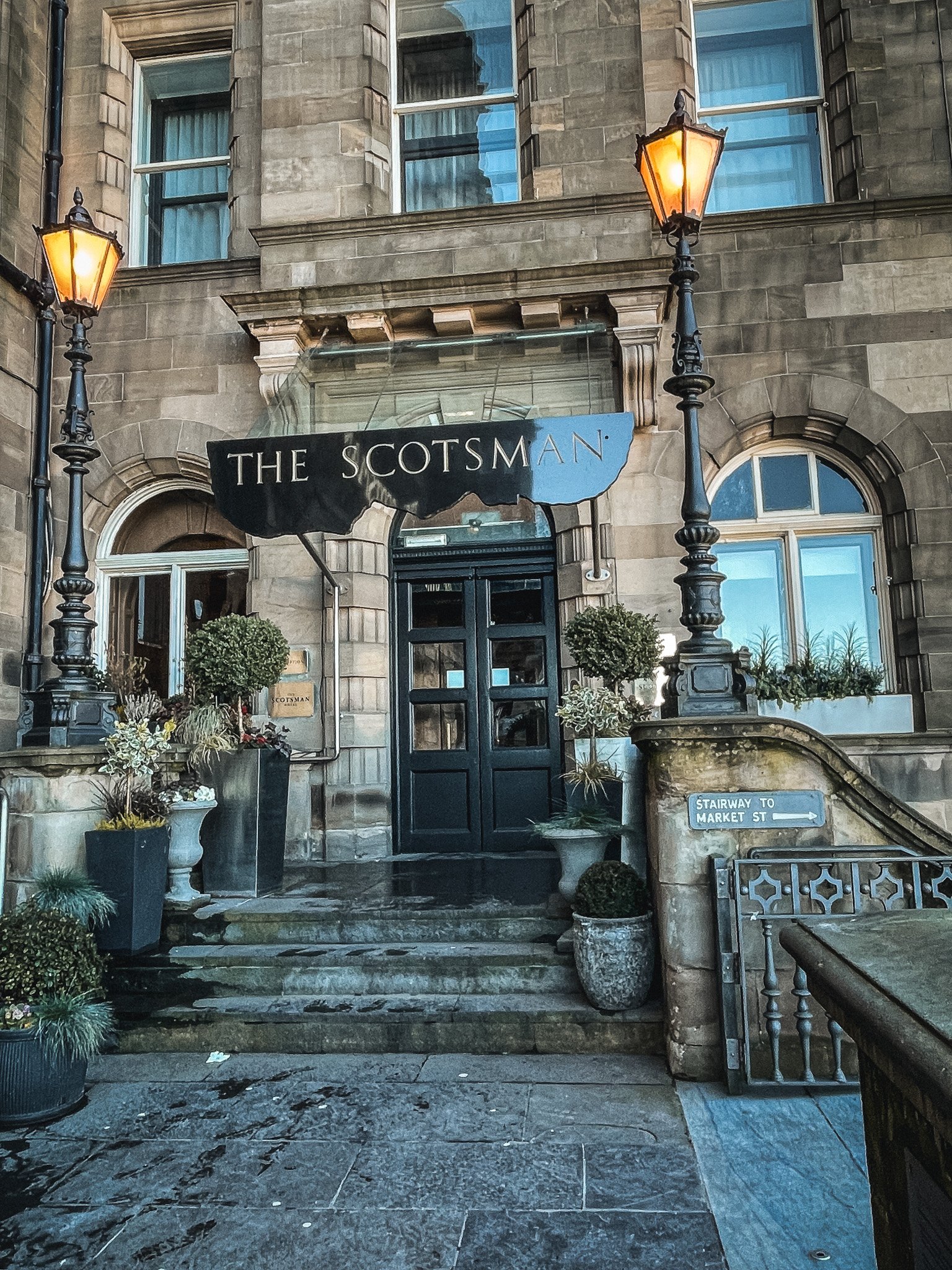 The Scotsman hotel entrance in Edinburgh Scotland with the lamps on