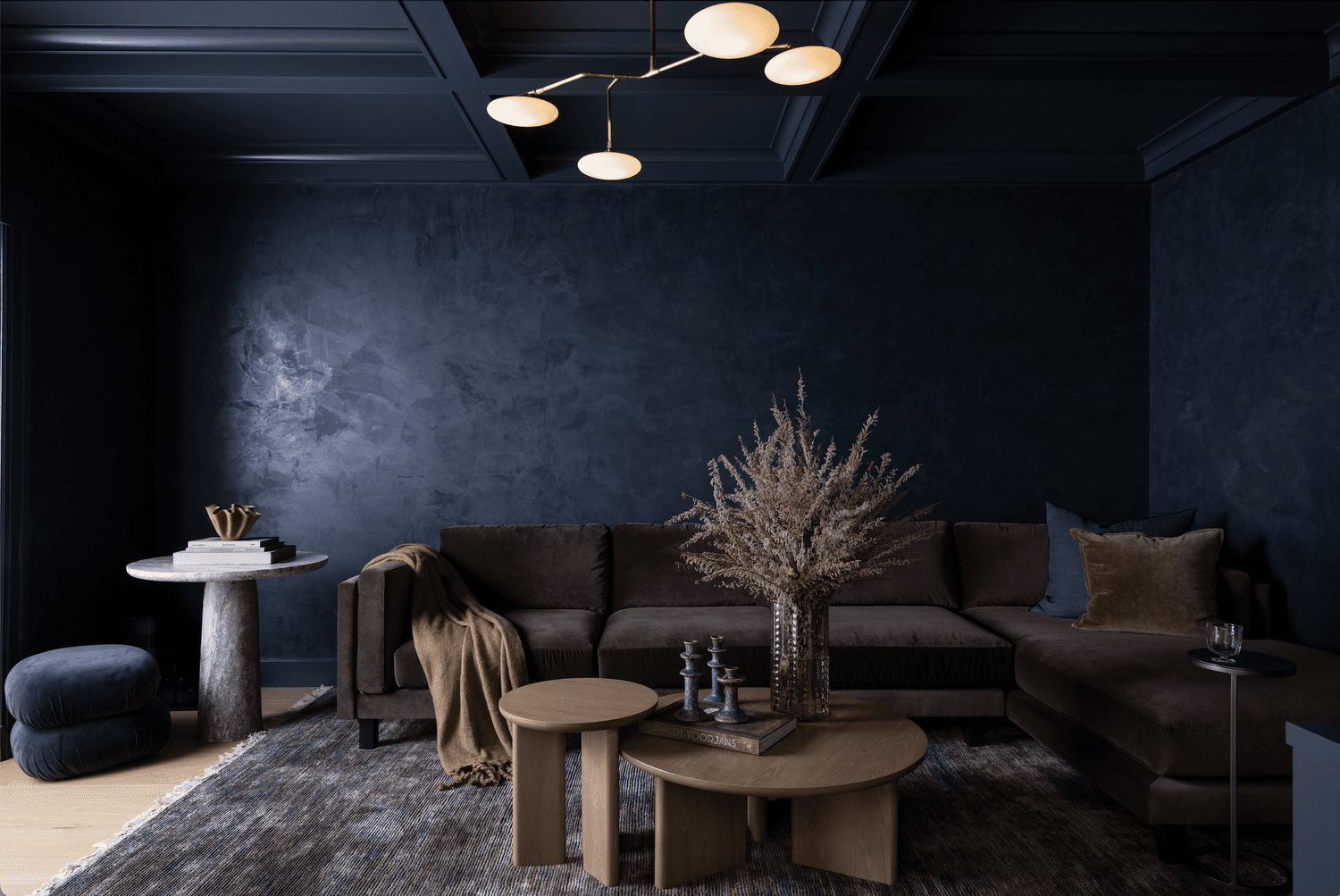 Moody living room with a deep navy ceiling, plum sectional sofa, sculptural brass chandelier, and layered neutral accents.